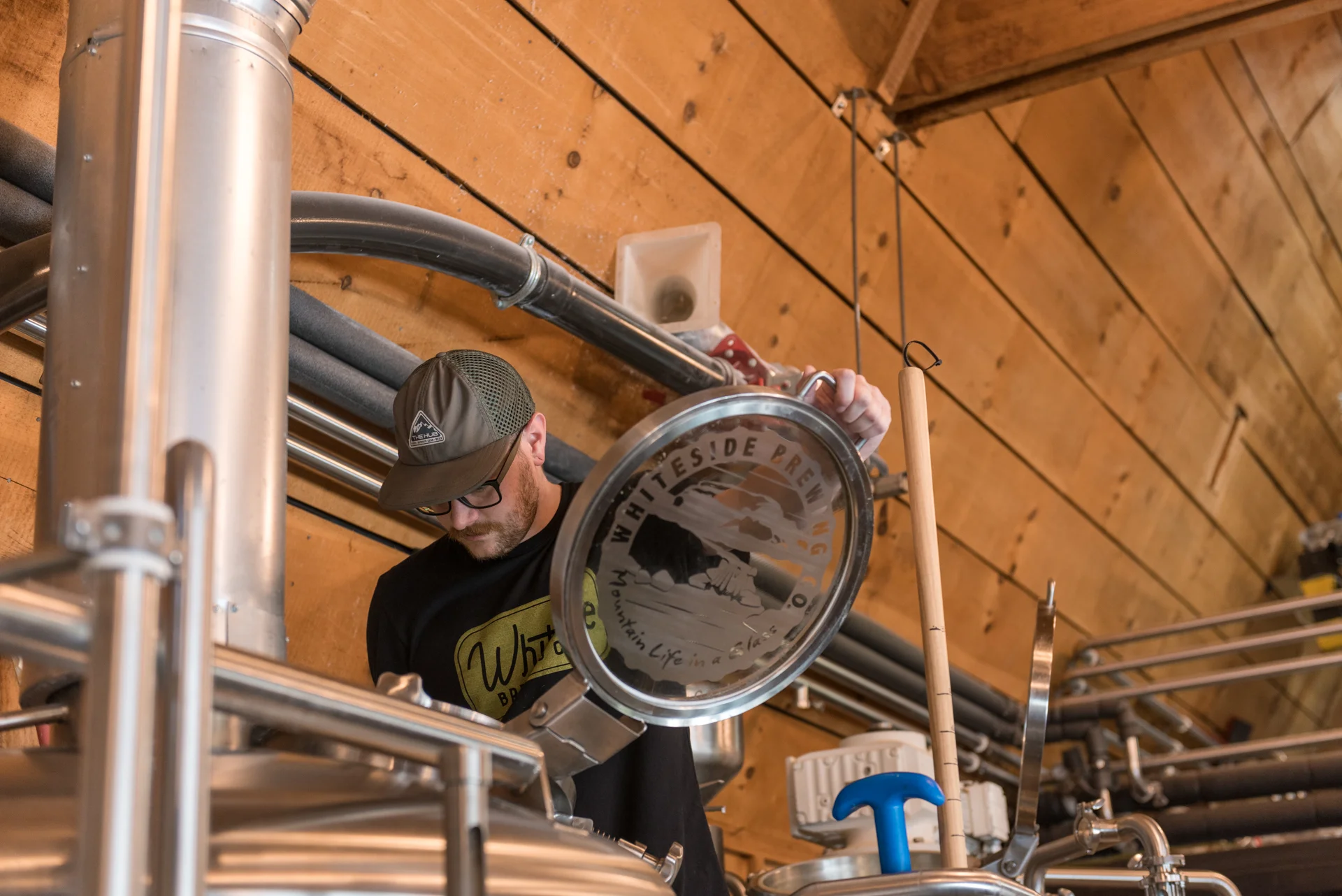Brewery worker inspecting brewing equipment
