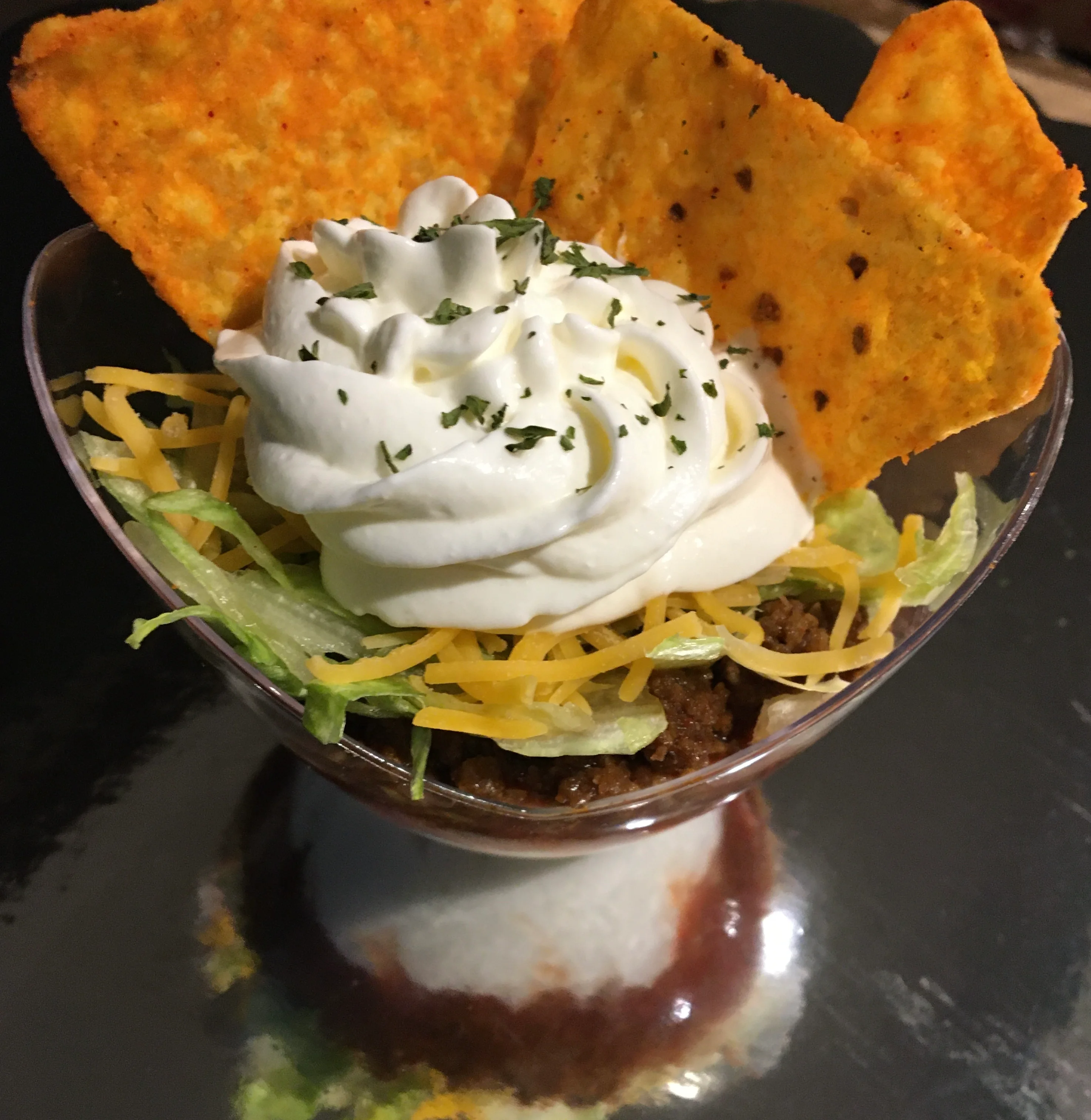 Taco salad served in a dessert cup with toppings