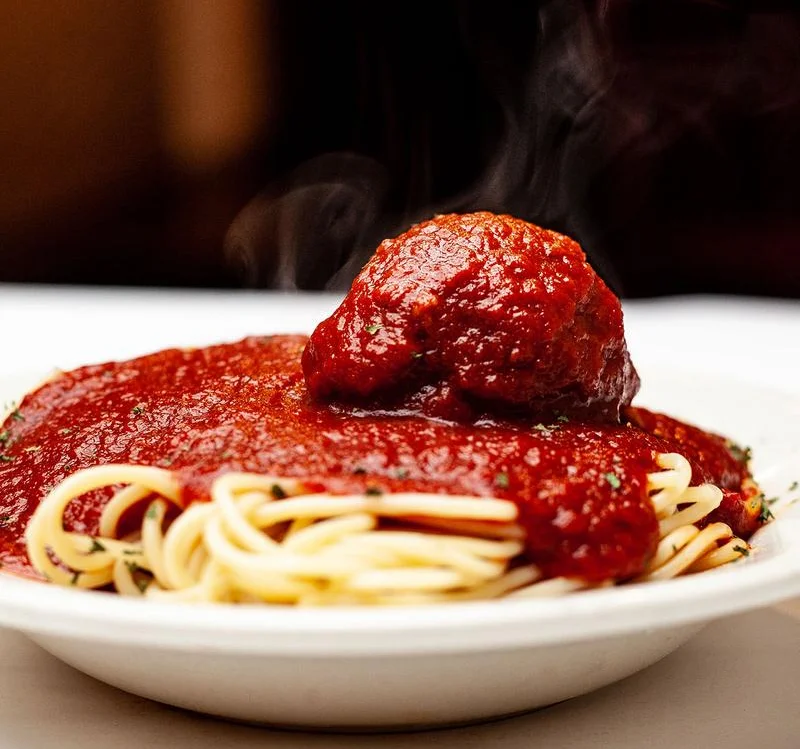 A steaming meatball atop a bed of fresh, delicious pasta, coated in our house-made marinara sauce.