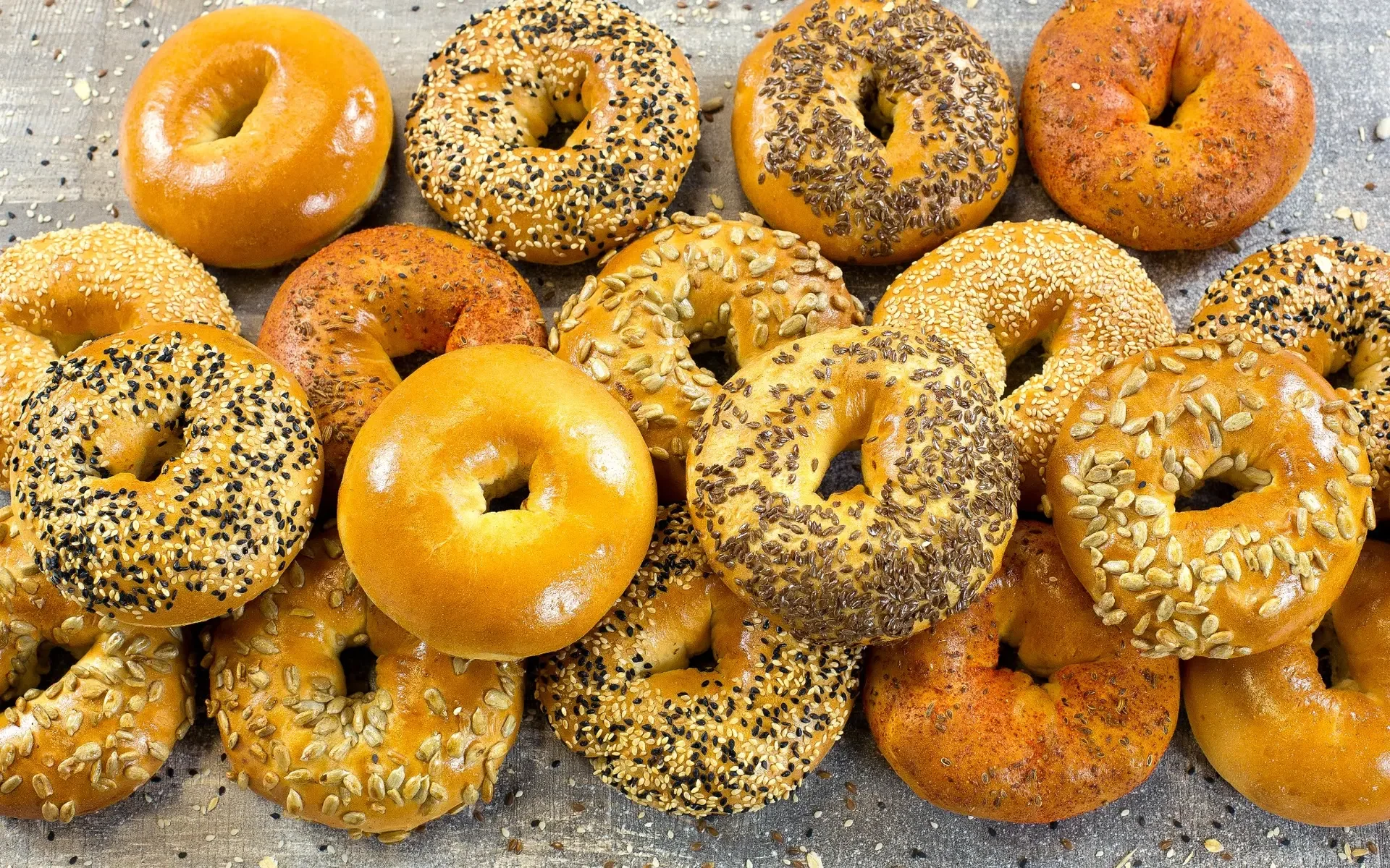 Assorted bagels with various toppings on a rustic surface