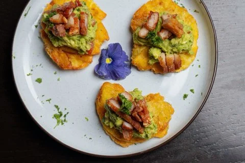 Puerto Rican tostones topped with guacamole and bacon