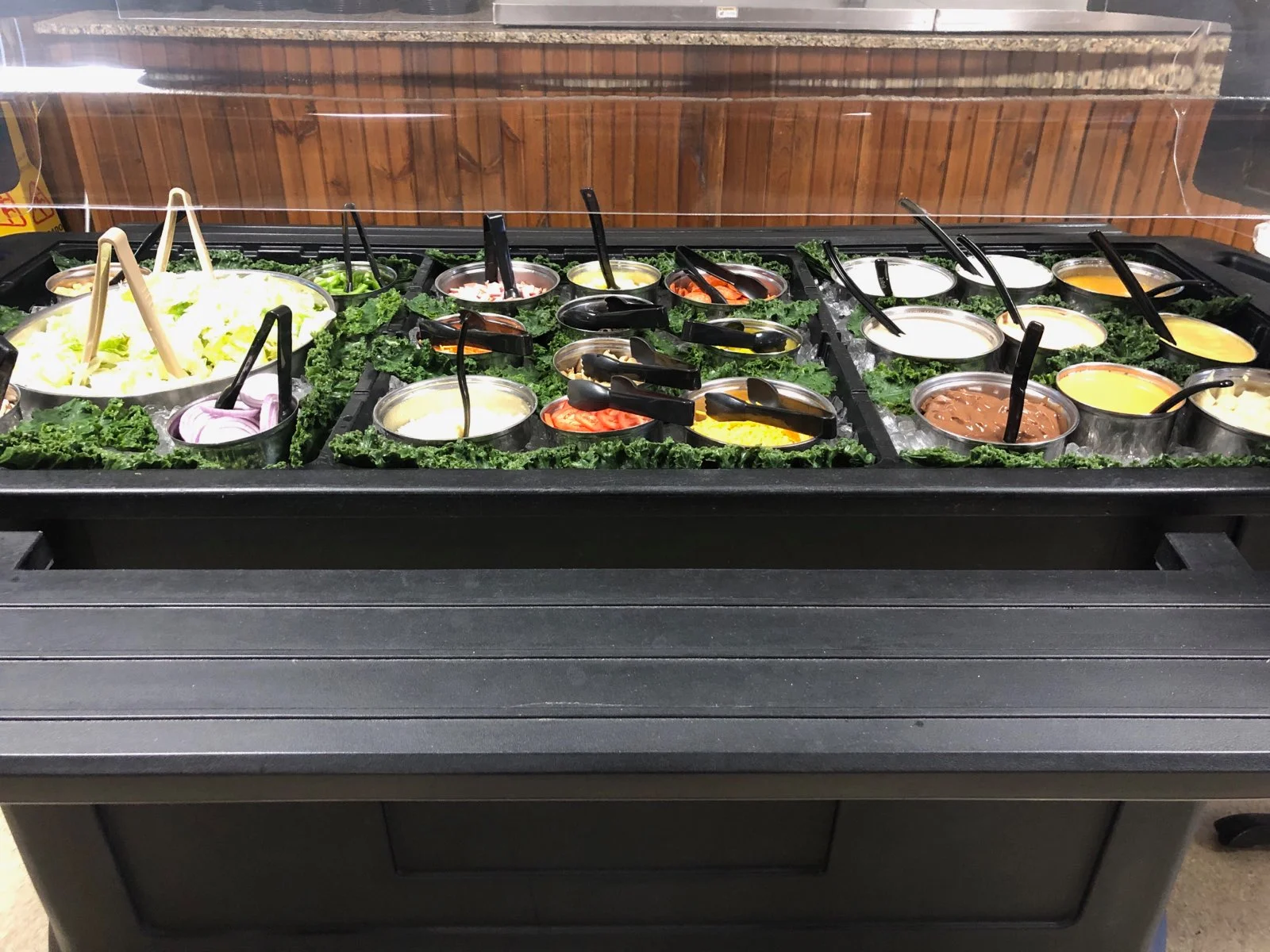 Salad bar with various toppings and dressings