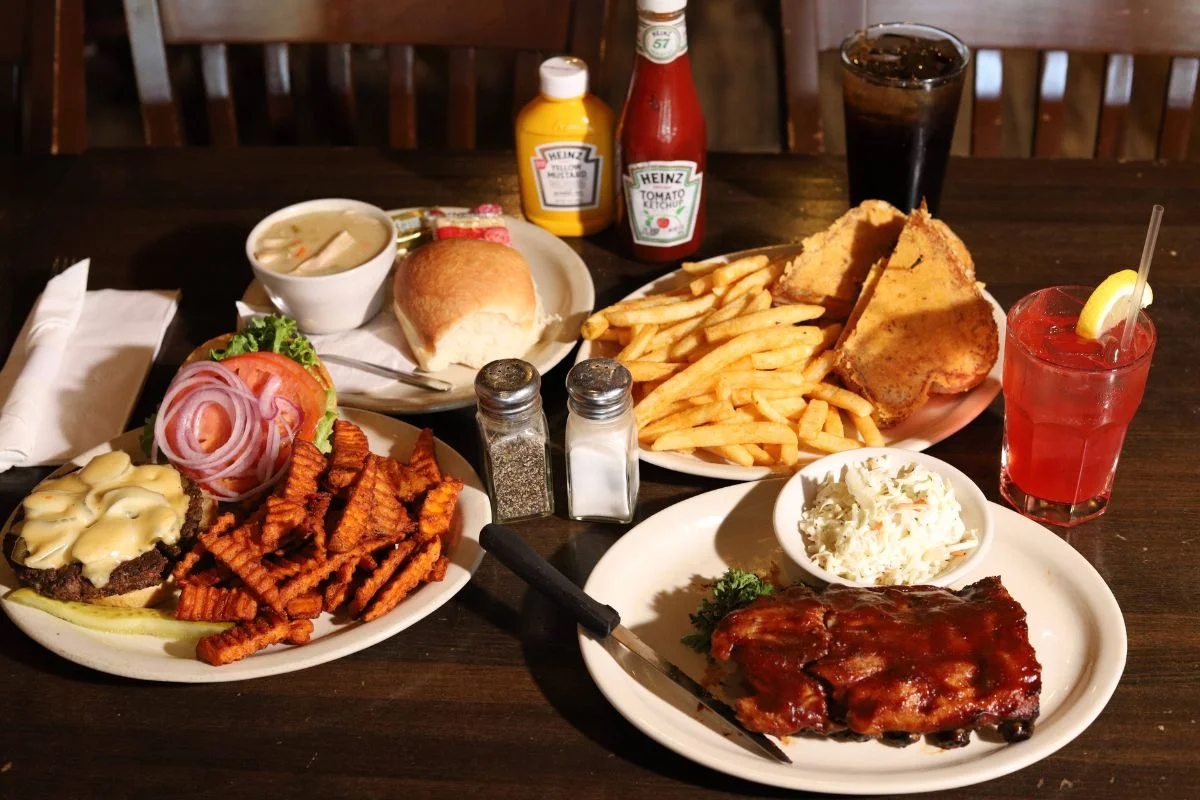 Mixed meal beautifully arranged with popular foods such as burgers, fries, nachos, and ribs