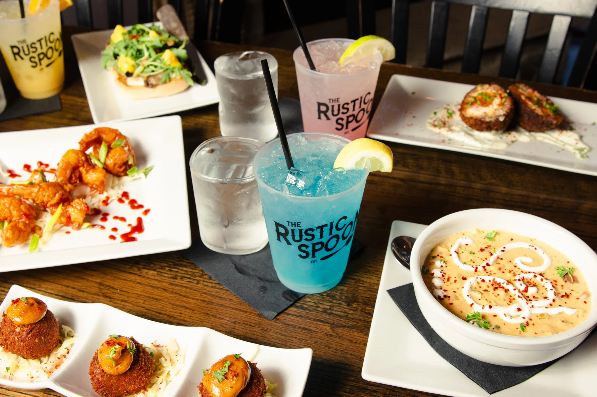 Colorful spread of Asian-inspired dishes and cocktails at a rustic restaurant