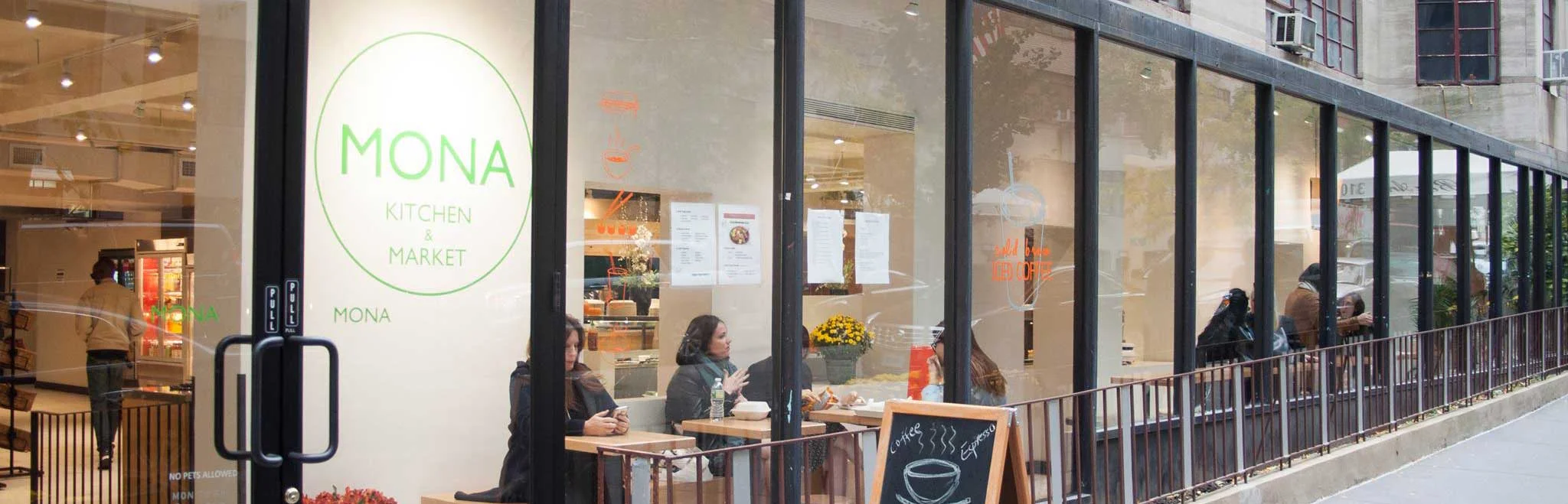 Modern restaurant exterior with large windows and outdoor seating