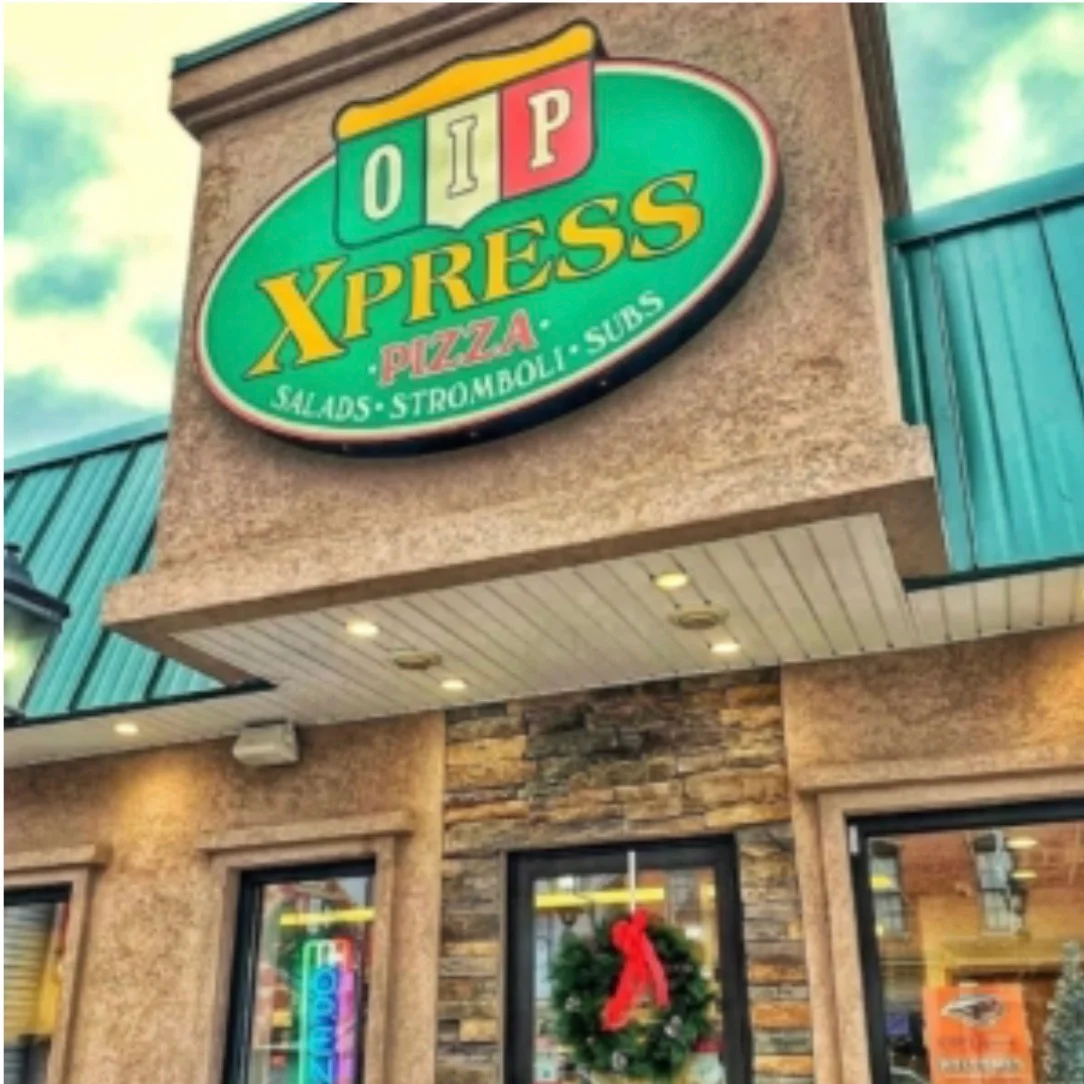 Exterior view of OIP Xpress Pizza restaurant with festive wreath