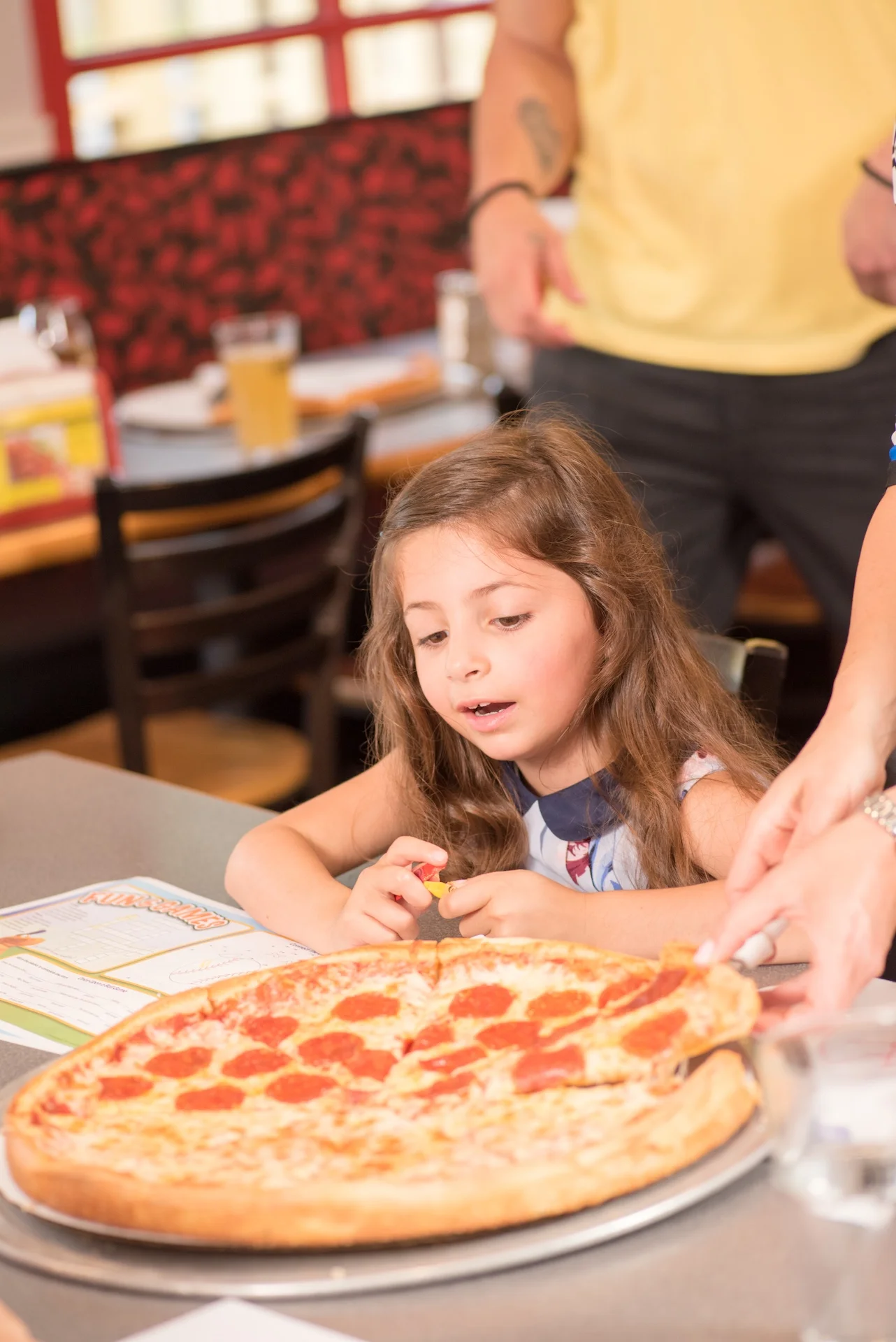 Child excitedly enjoying a pepperoni pizza at a family restaurant