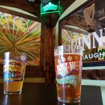Two craft beers on a bar counter with vibrant decor