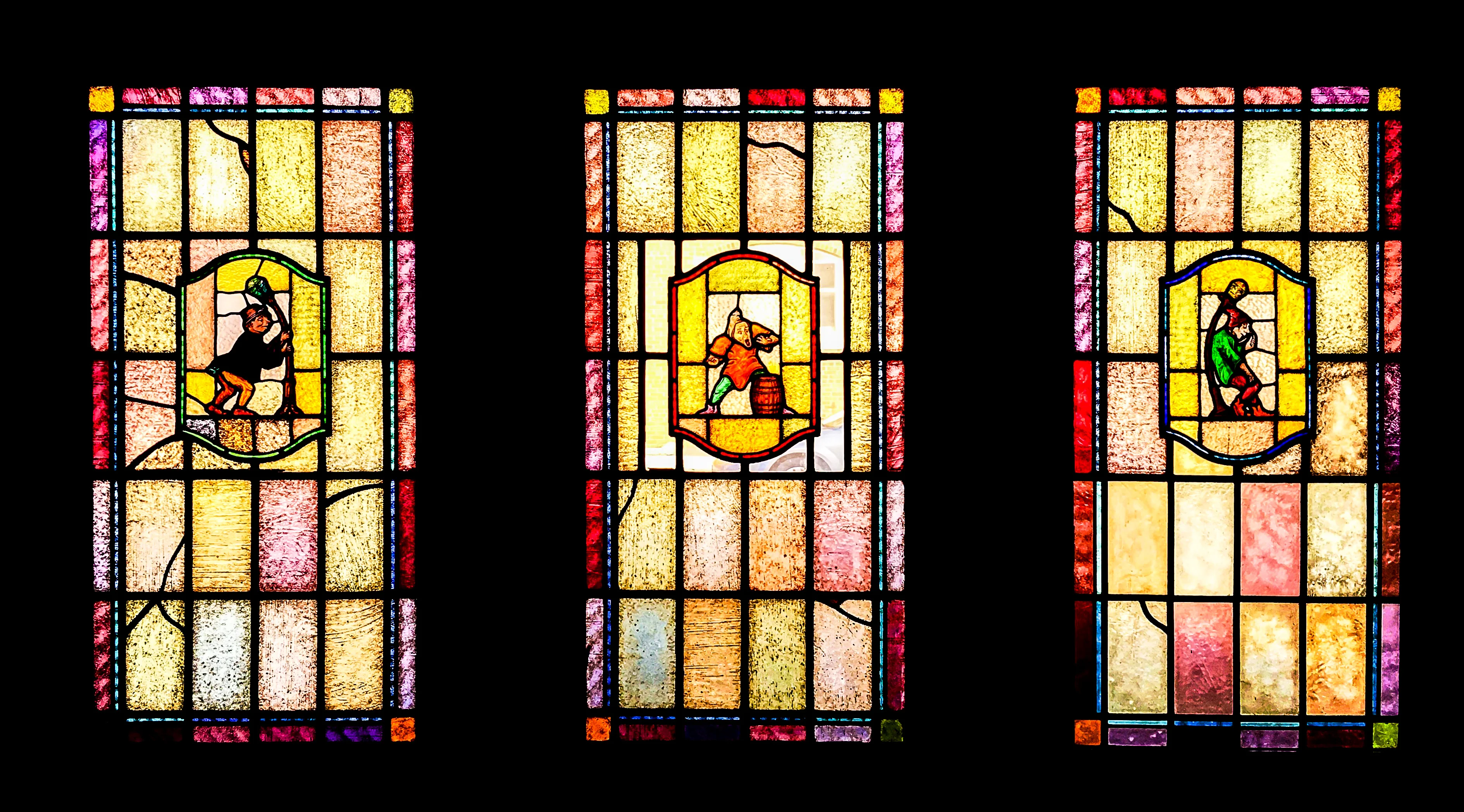 Colorful stained glass windows depicting various scenes