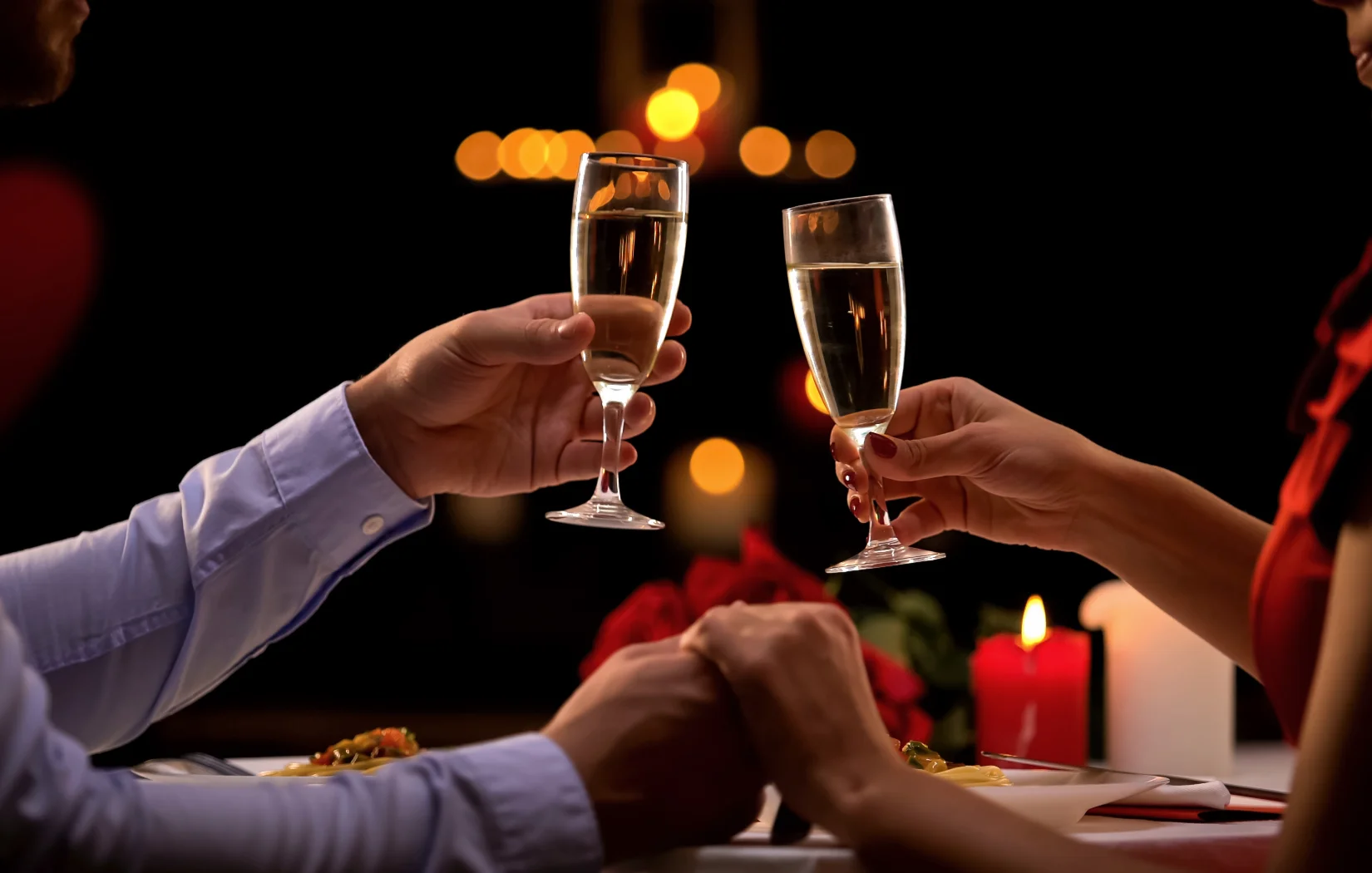 Couple toasting with champagne glasses at a romantic dinner