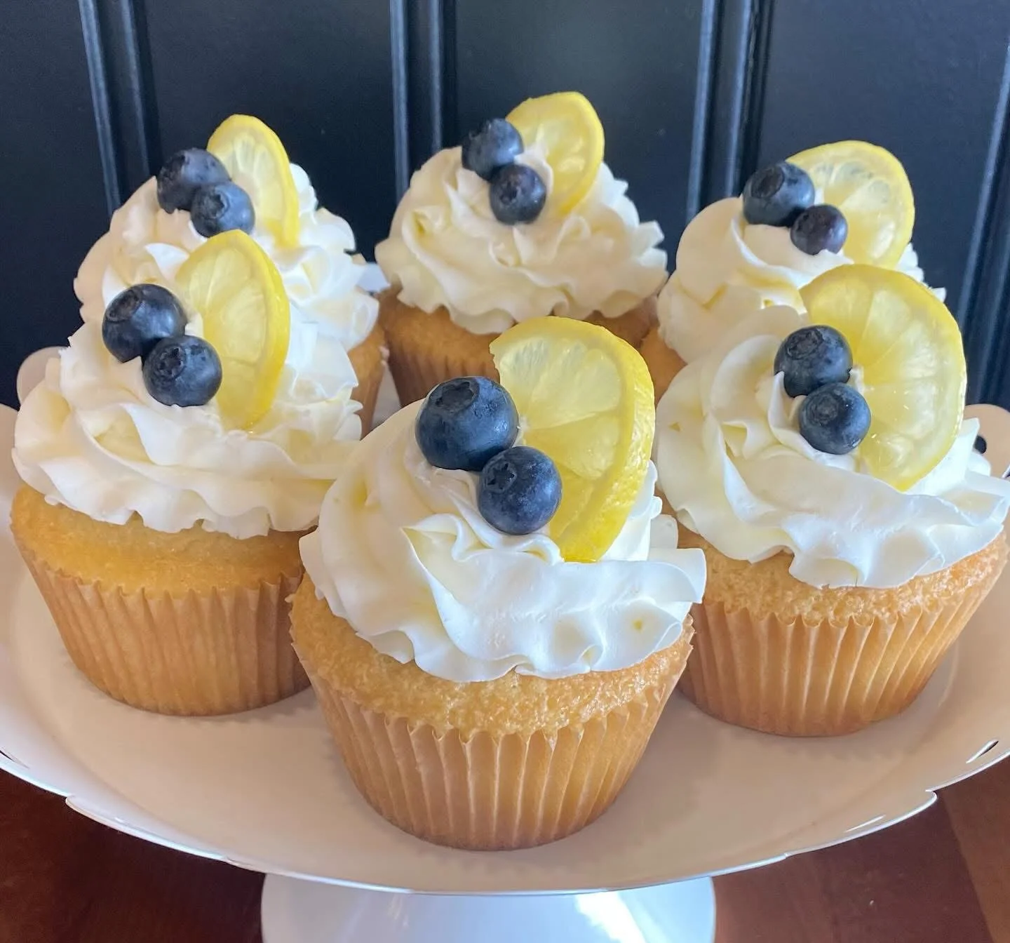 Lemon blueberry cupcakes on a white cake stand