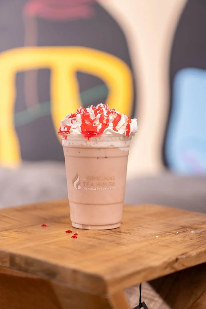 Delicious milkshake topped with whipped cream and cherry syrup
