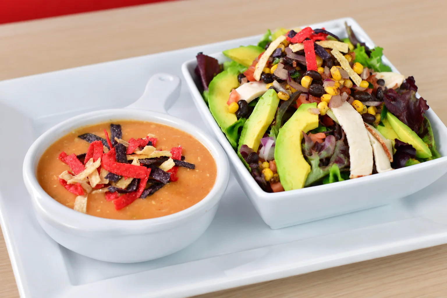 Mexican-inspired chicken taco salad with tortilla strips and bean soup