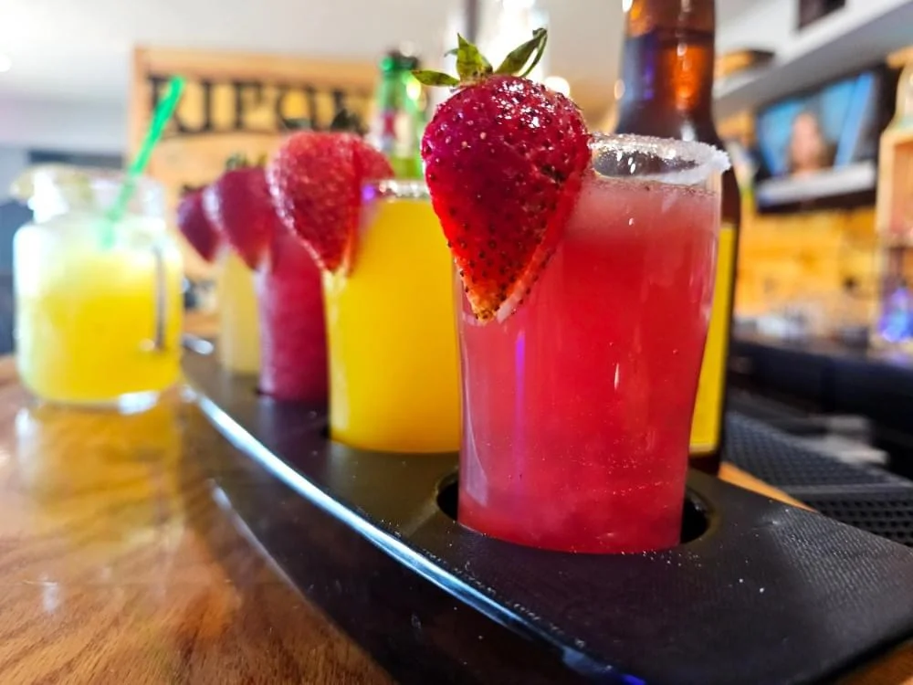 Colorful cocktails with fresh fruit garnishes at a vibrant bar
