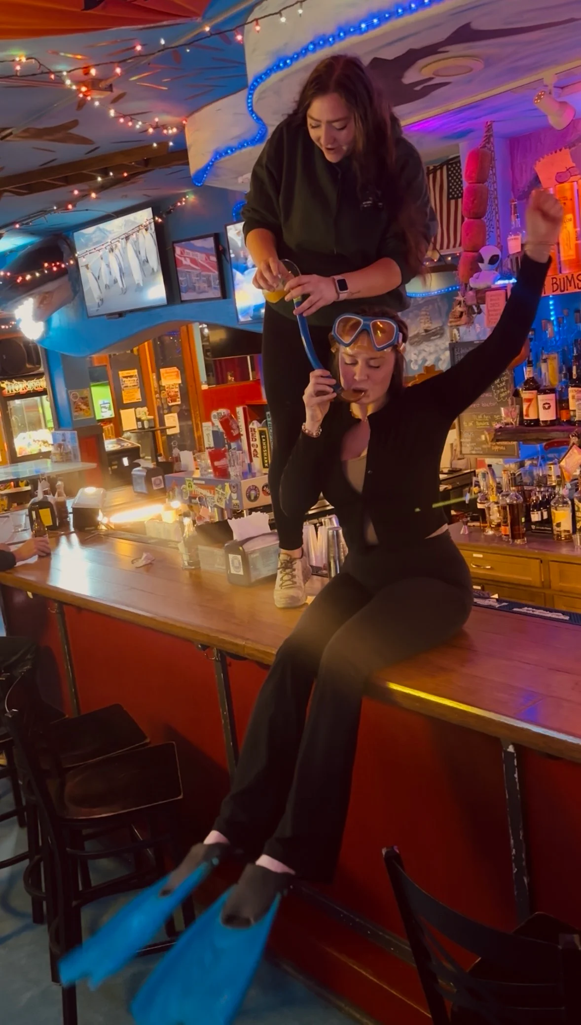 Fun bar scene with staff in snorkeling gear and cocktails