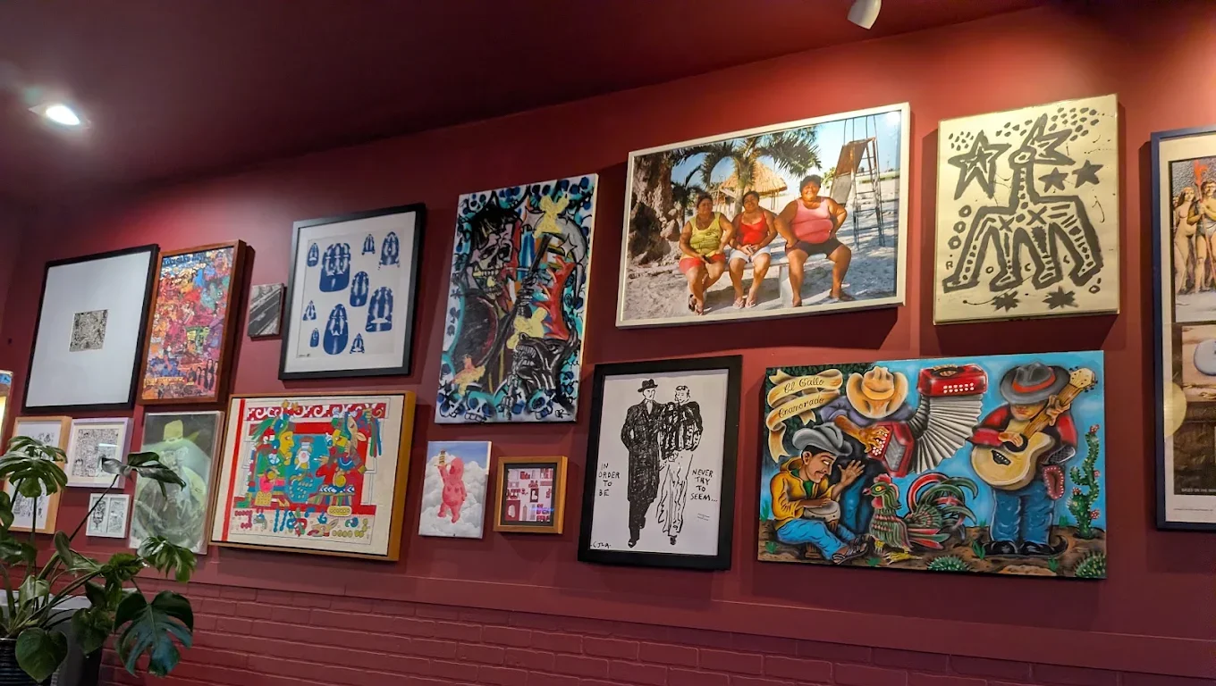 Inside Hayes Burger on Adams Ave in Normal Heights — deep red walls hung with framed art above painted brick