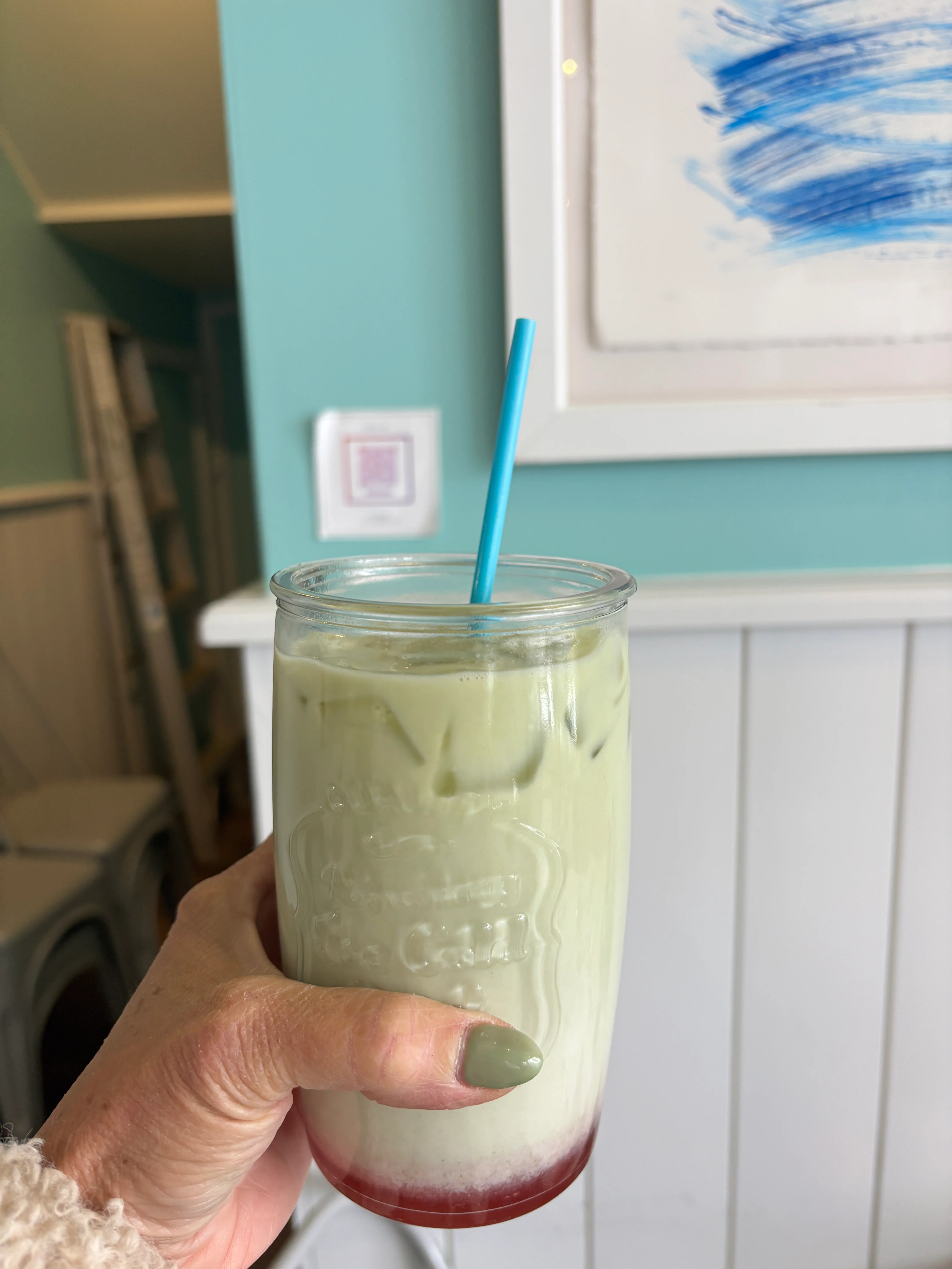 Iced matcha latte with a colorful layer in a glass jar