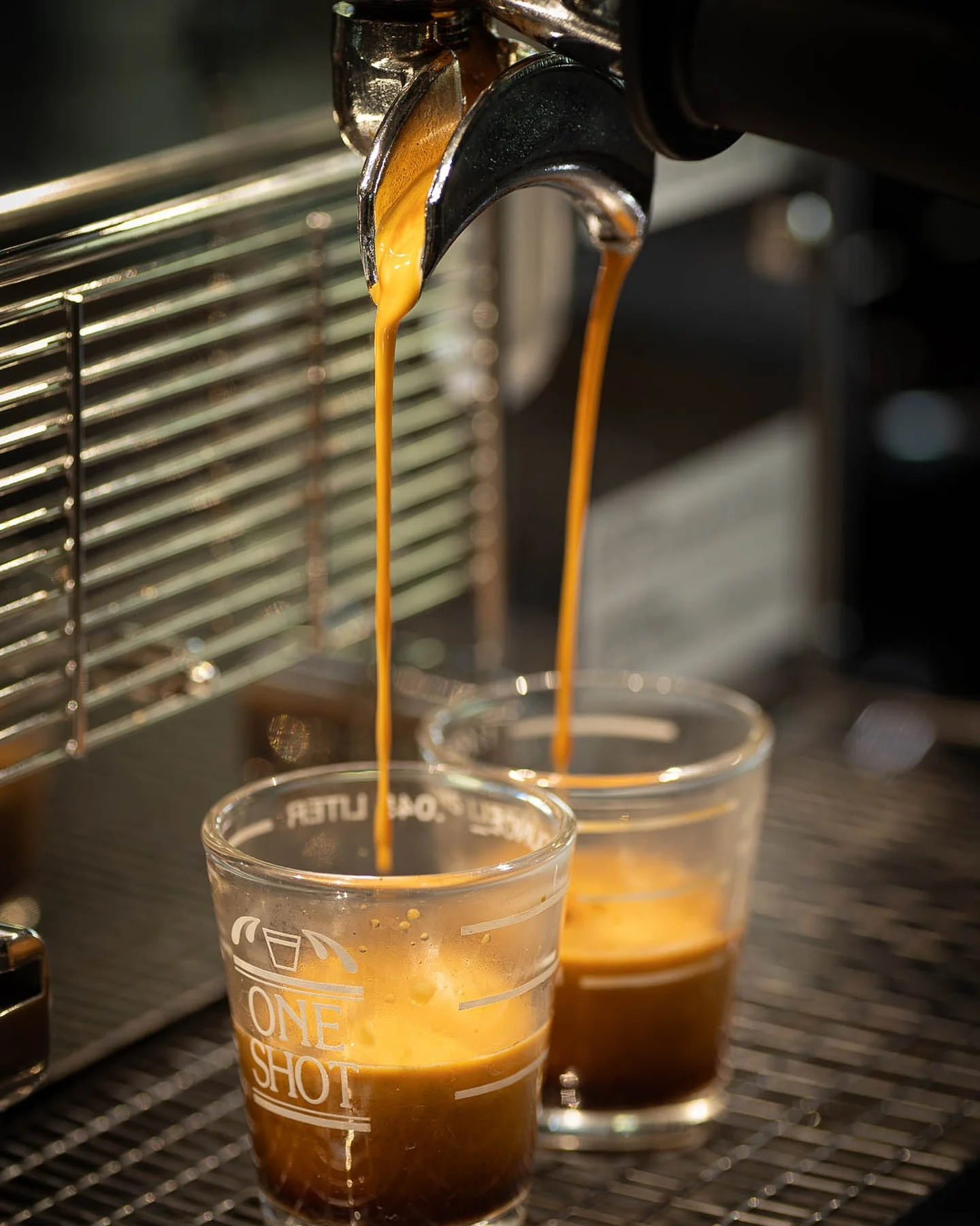 Freshly brewed espresso shots pouring into glasses