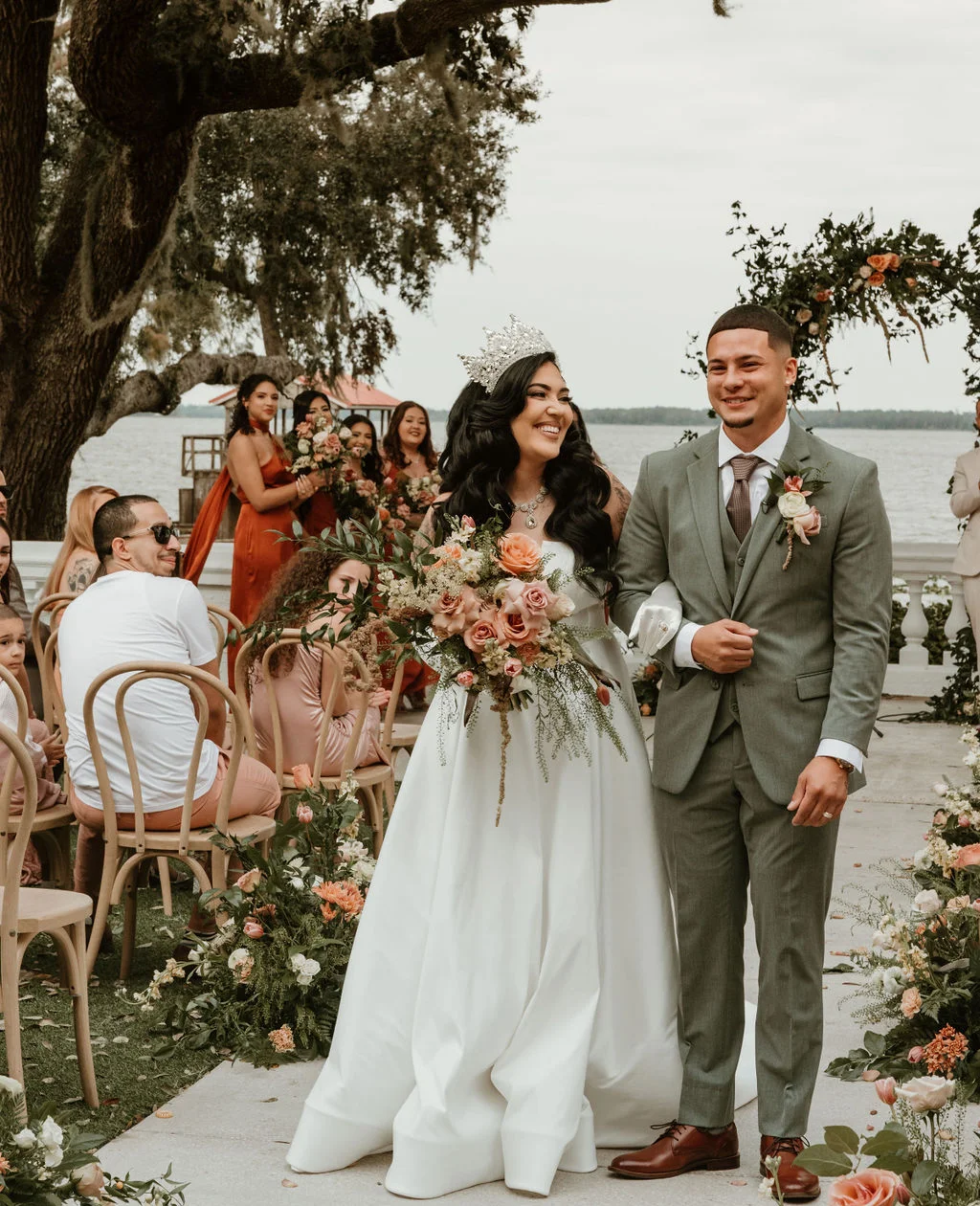 Bride and groom celebrating their wedding outdoors by the water