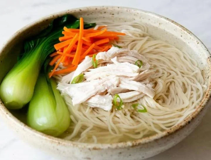 Bowl of Chinese chicken noodle soup with bok choy