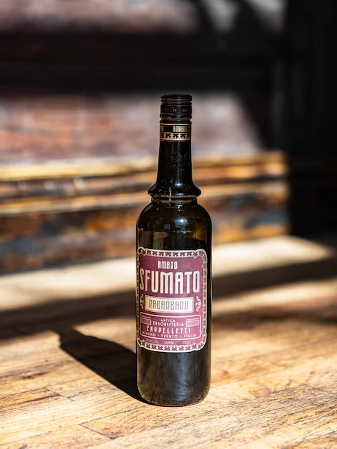 Bottle of Italian amaro liqueur on a wooden surface