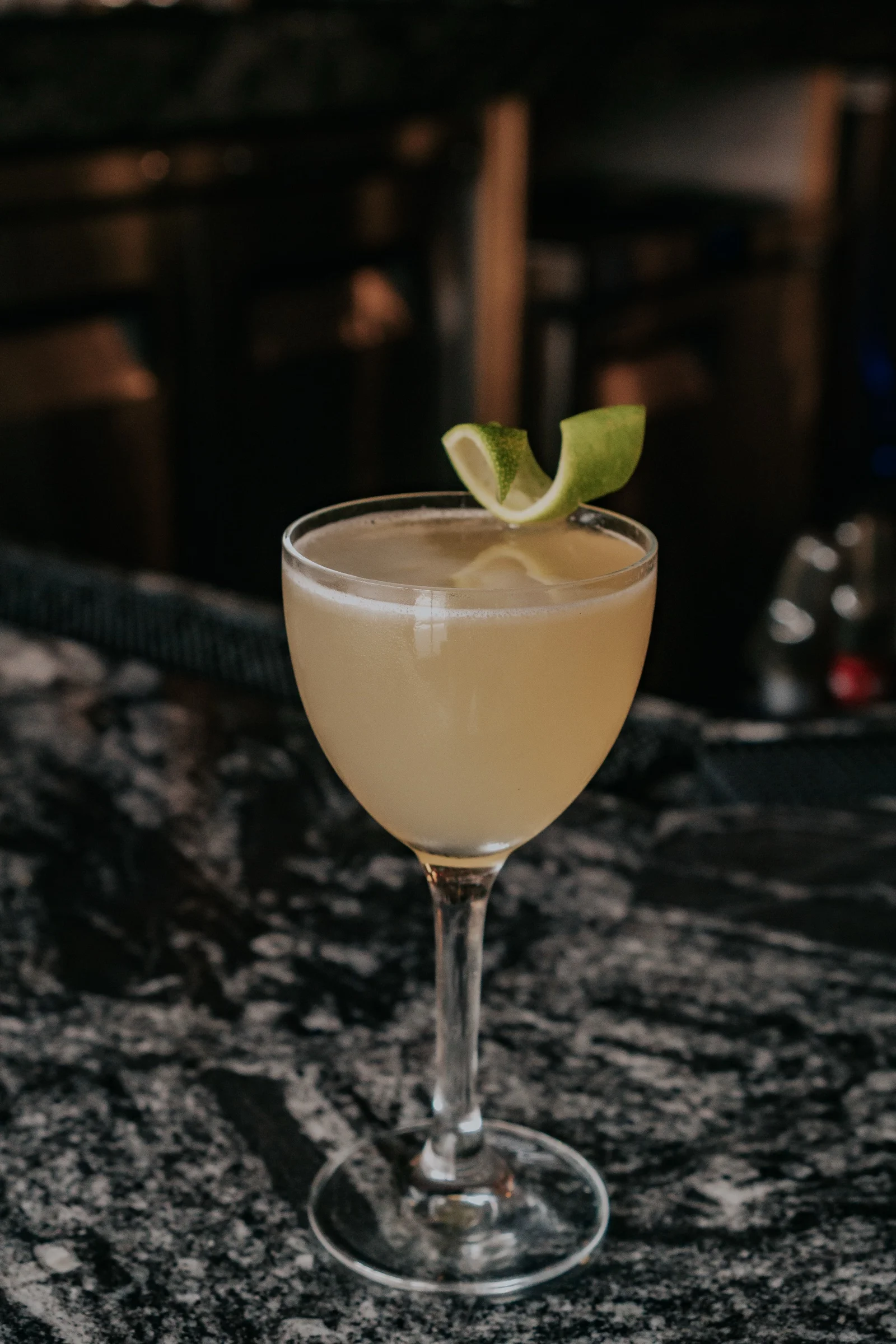 Drink in a stemmed glass with a citrus twist at Castro Indian Restaurant