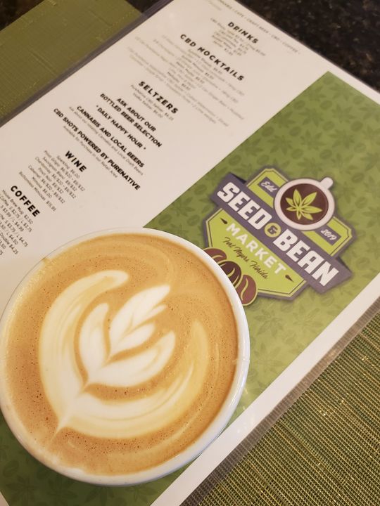 Latte beside a Seed and Bean Market menu
