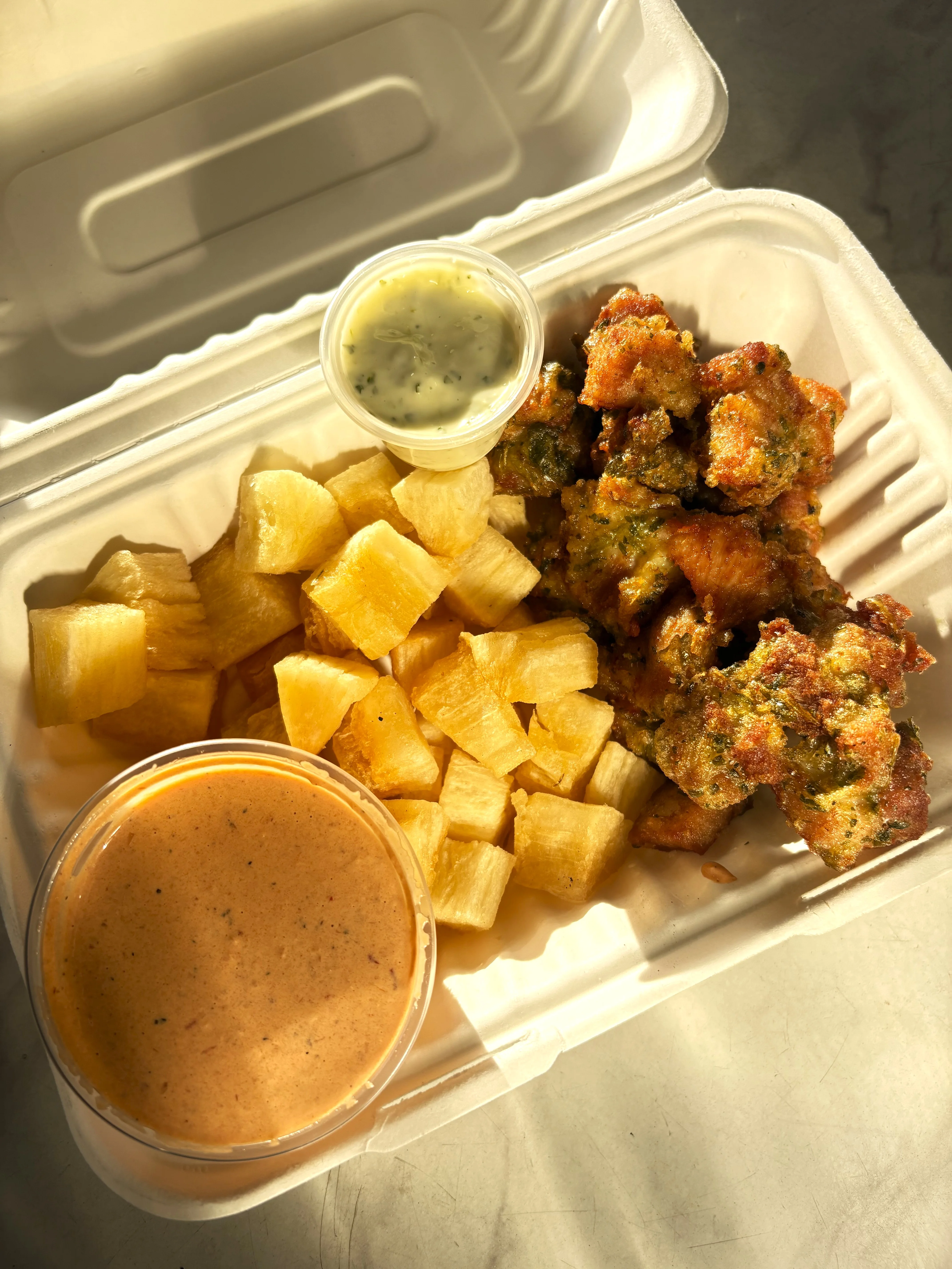 Fried plantain fritters with dipping sauce and diced pineapple