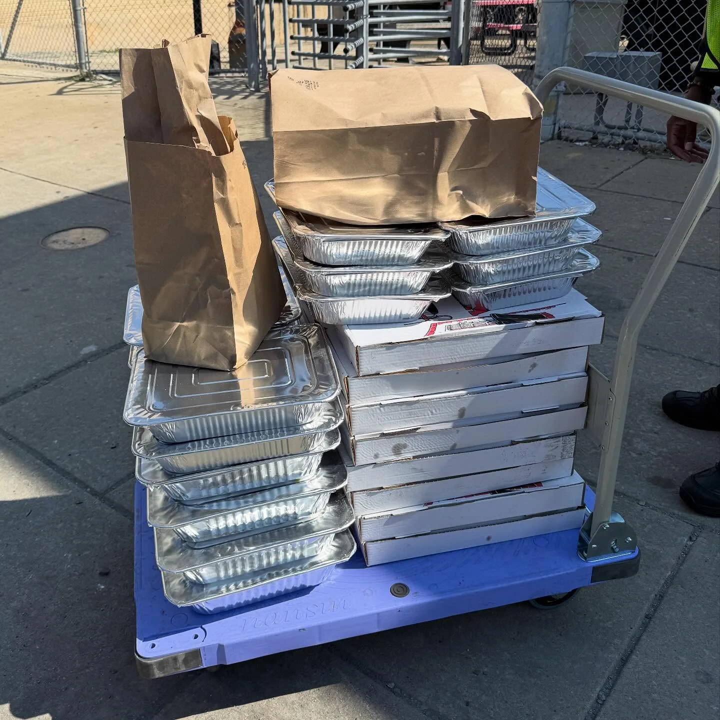 Catering cart loaded with food trays and bags for delivery