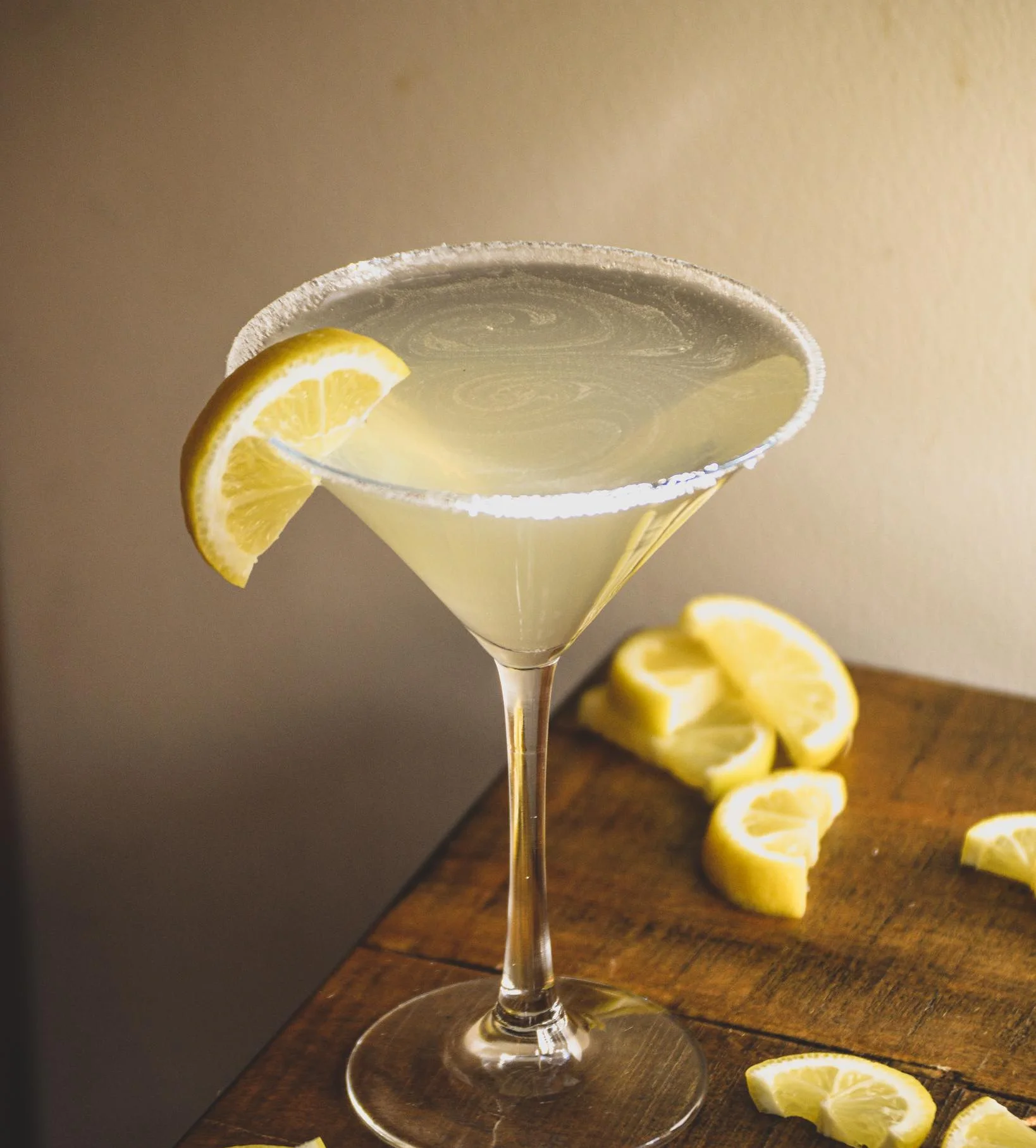 Lemon Drop Martini sitting in the sunlight surrounded by lemon slices