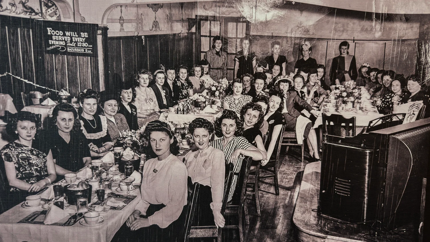 Vintage dining scene with women at a long table