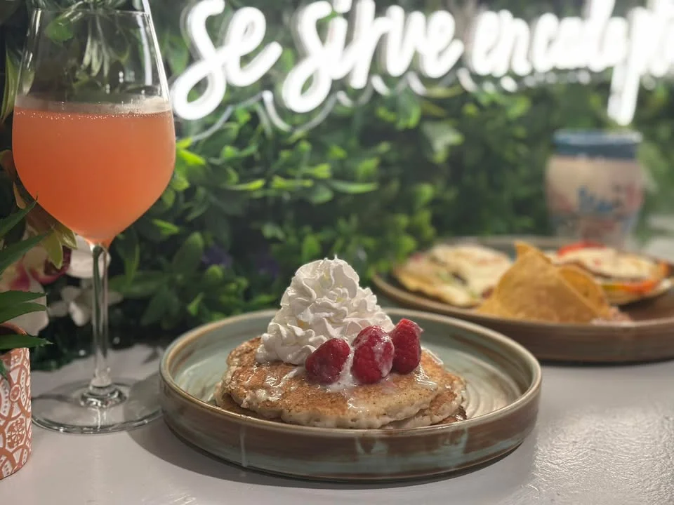 Fluffy pancakes topped with whipped cream and raspberries