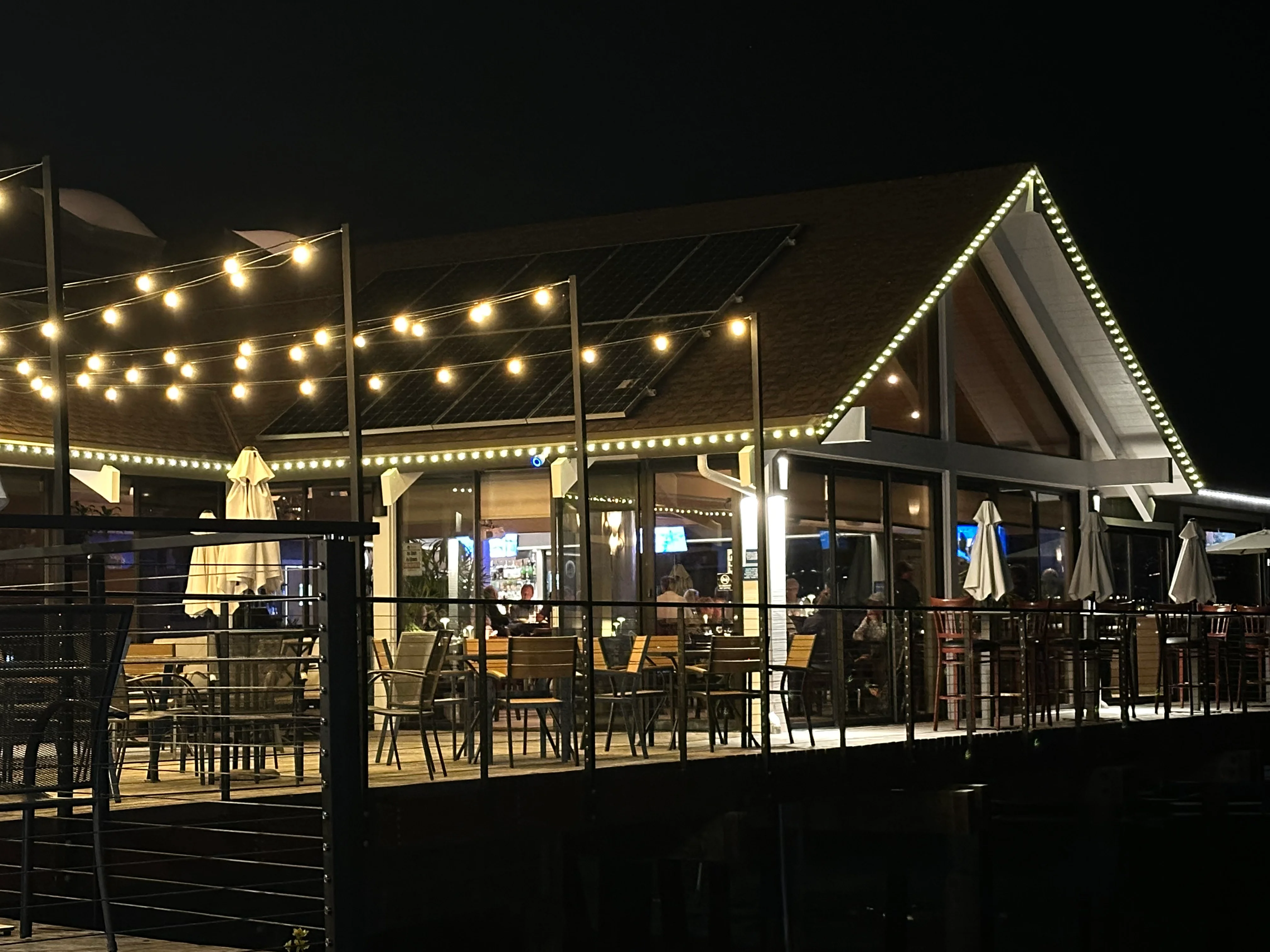 Charming waterfront restaurant illuminated at night with outdoor seating