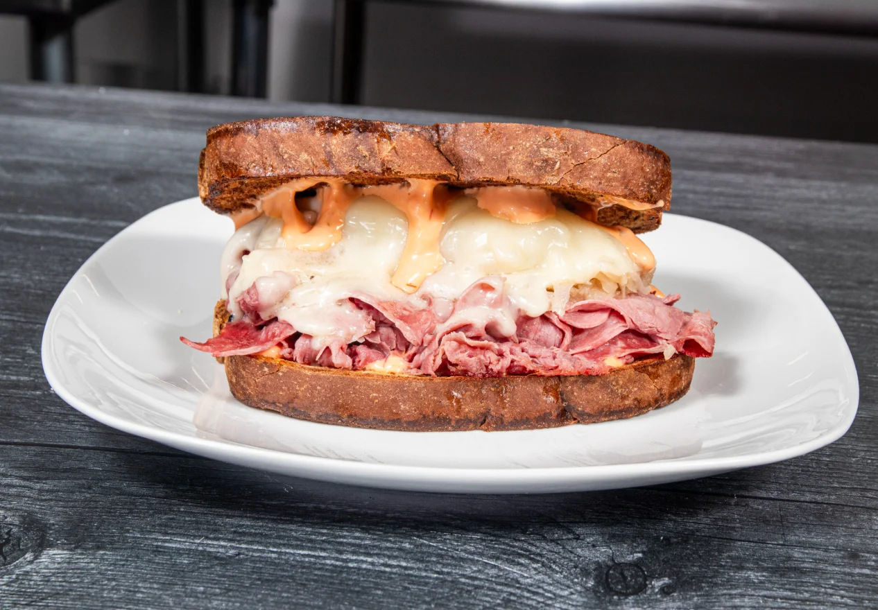 A delicious Reuben sandwich with corned beef, sauerkraut, and Swiss cheese.