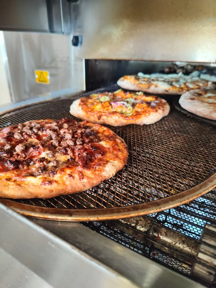 Freshly baked pizzas inside a commercial pizza oven