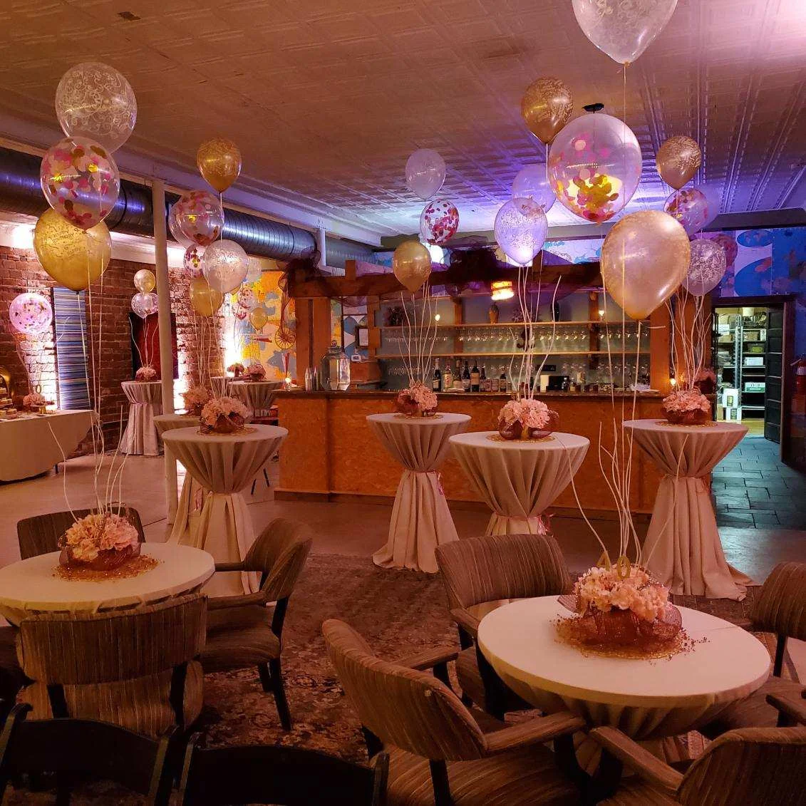 Elegant event space with balloons and floral centerpieces