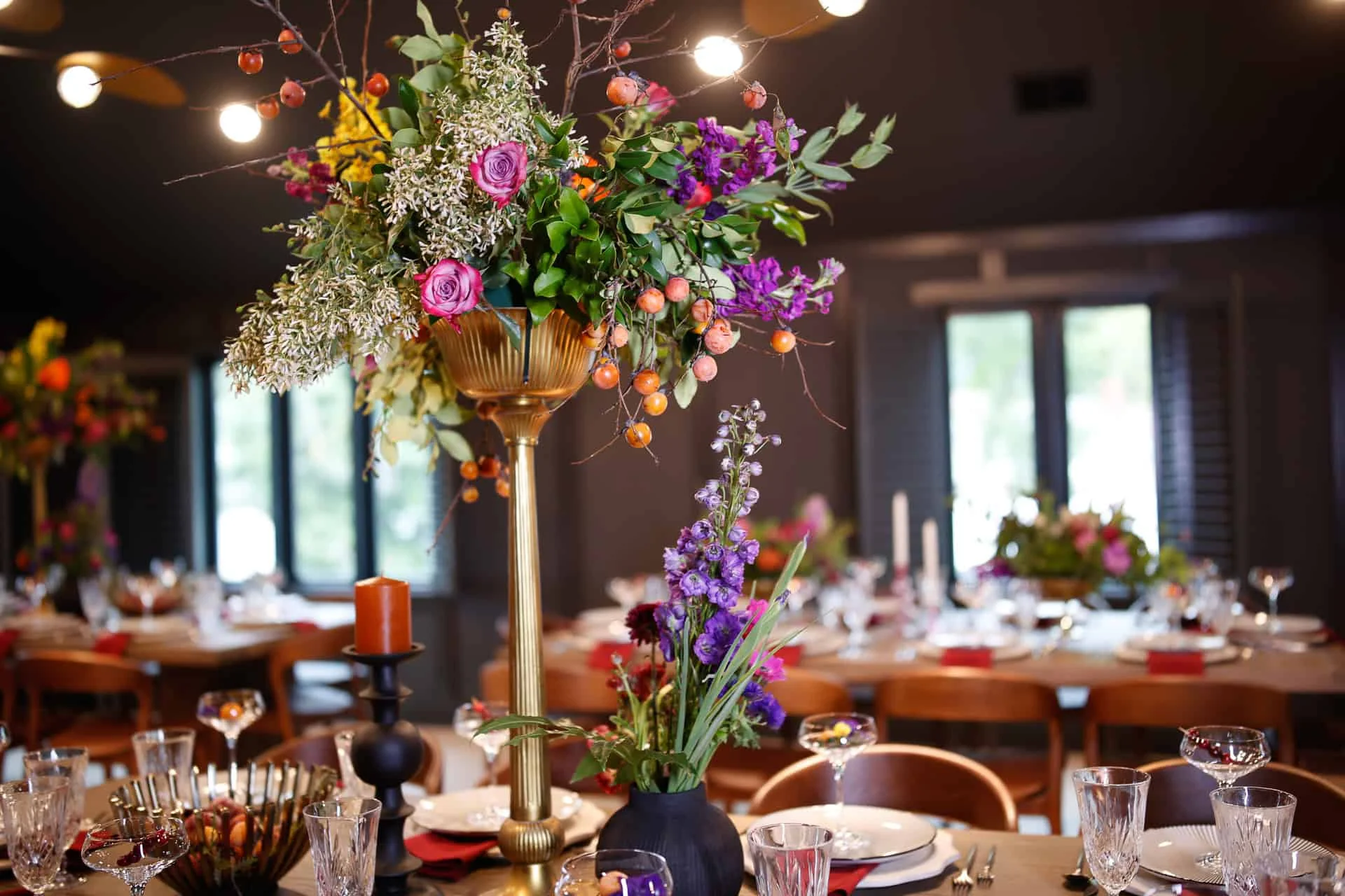 The Embers Room private event floor above Firetender in Manteo, NC, dressed with tall floral centerpieces for a private dinner
