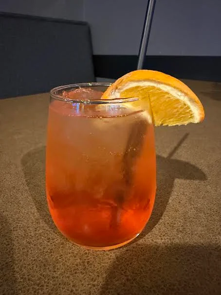 A refreshing Aperol Spritz cocktail garnished with an orange slice.