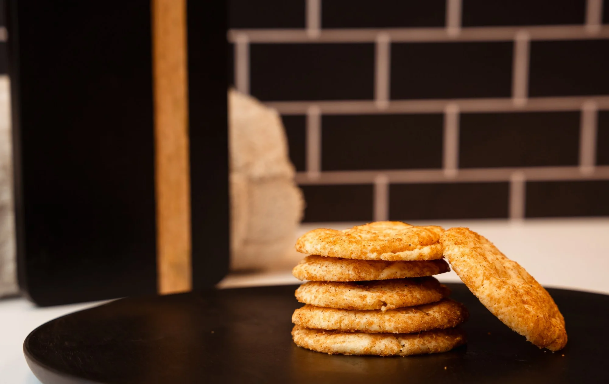 Freshly baked snickerdoodle cookies on a black plate