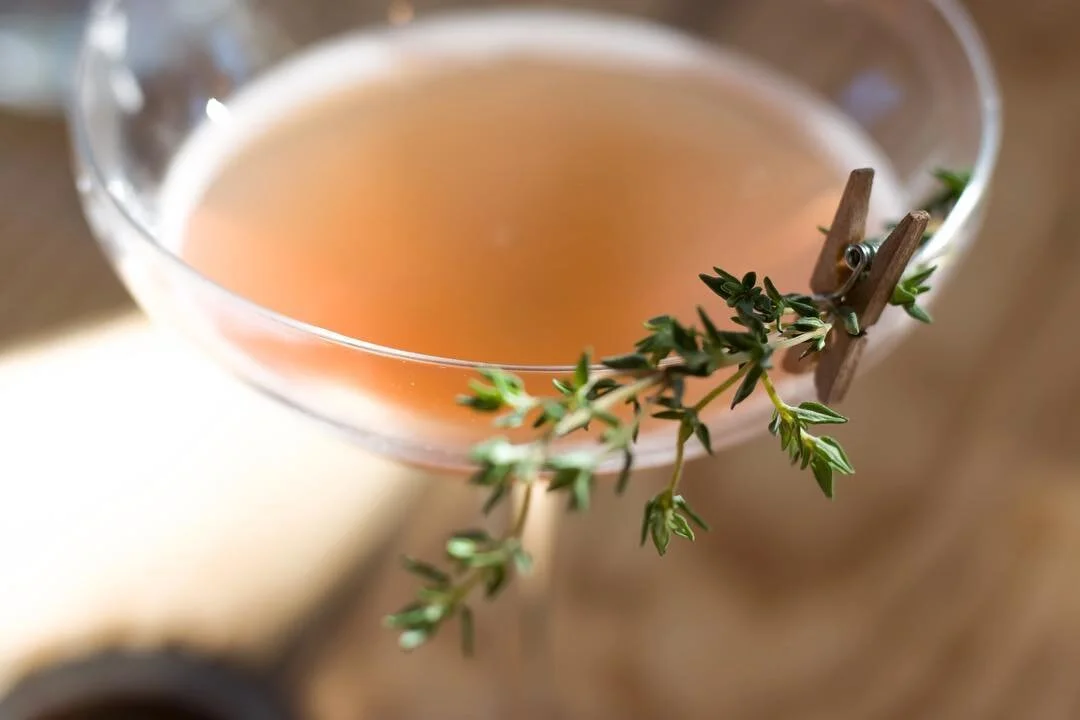 Craft cocktail garnished with fresh thyme