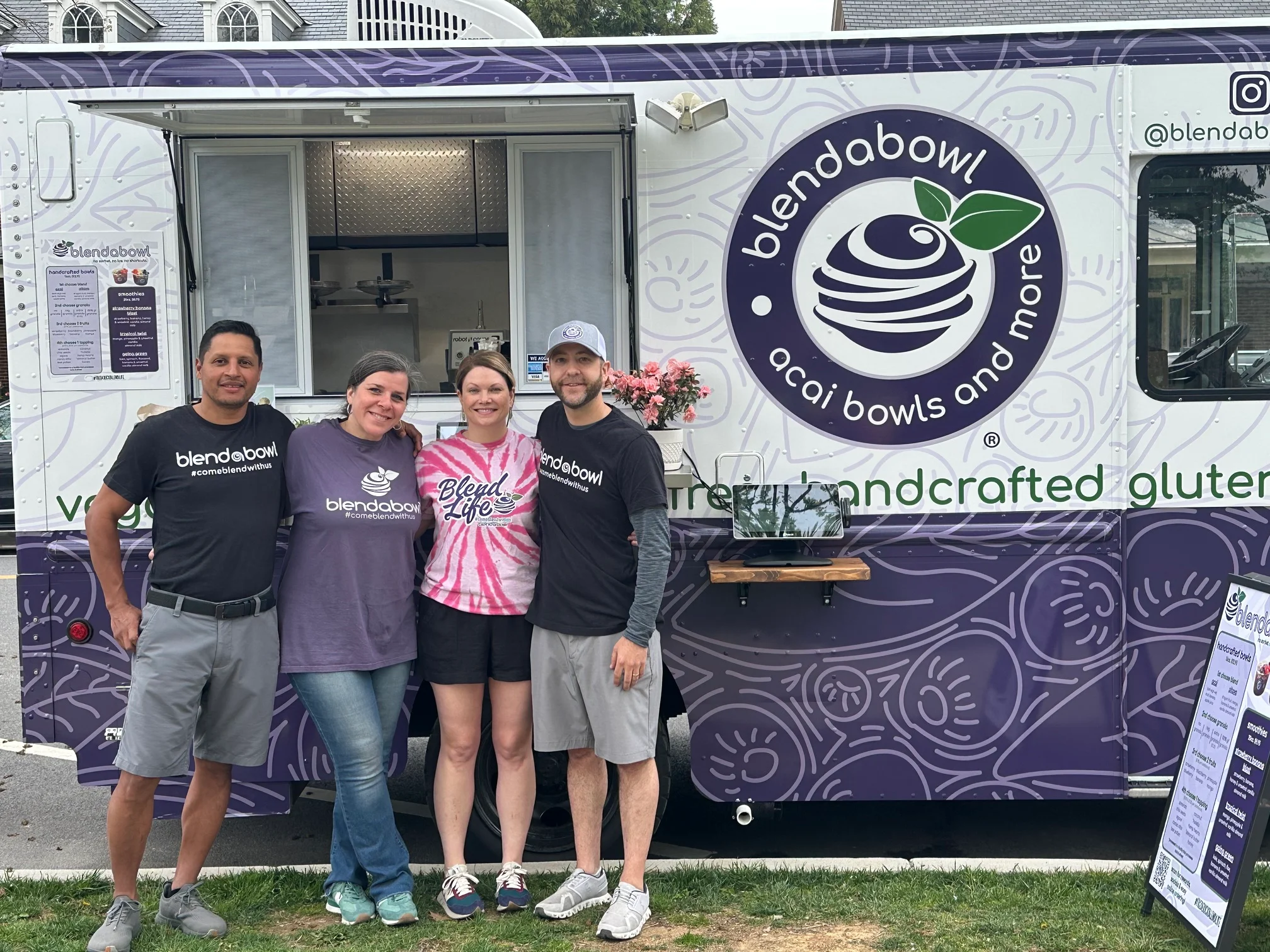 Restaurant team posing outside a vibrant acai bowl food truck
