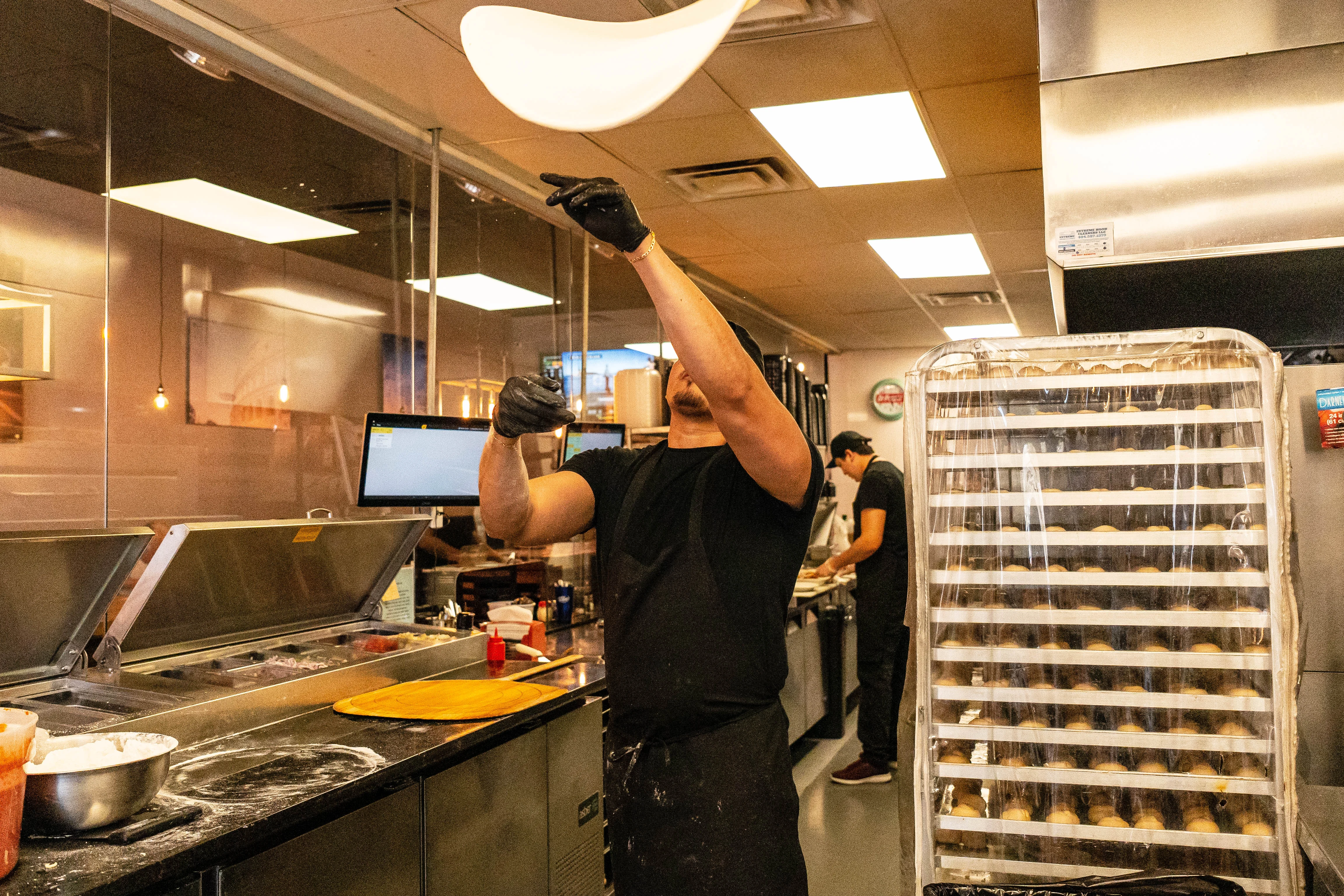 Chef tossing pizza dough in a modern kitchen