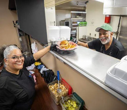 Chefs serving a vibrant platter of soul food in a restaurant kitchen