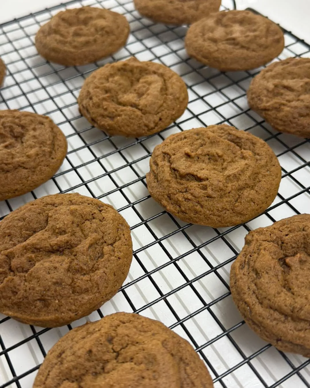 Freshly baked cookies cooling on a wire rack, showcasing their soft and inviting texture.