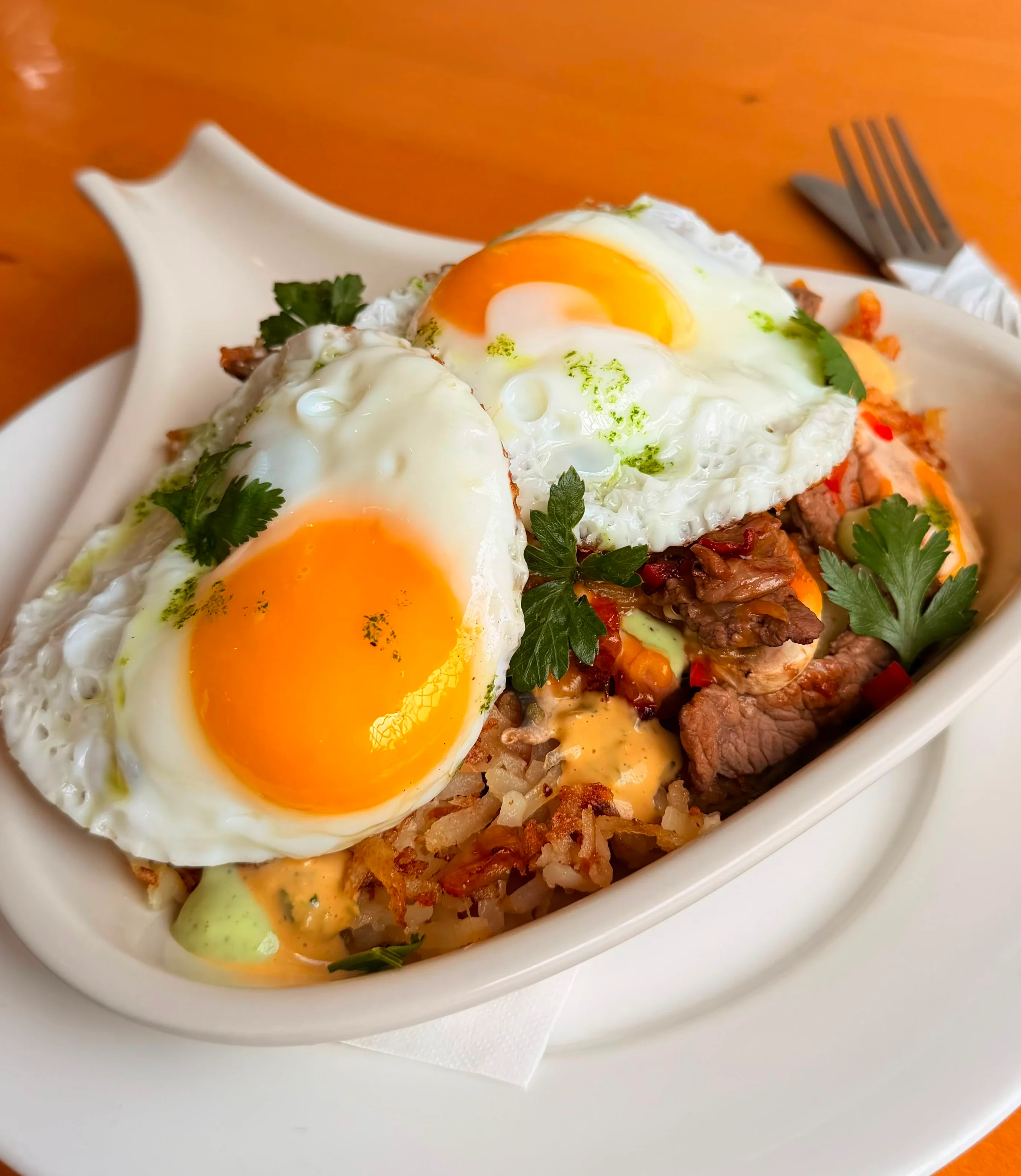 A delicious plate featuring a sunny-side-up egg on a bed of seasoned hash, accompanied by three slices of whole grain toast on the side.