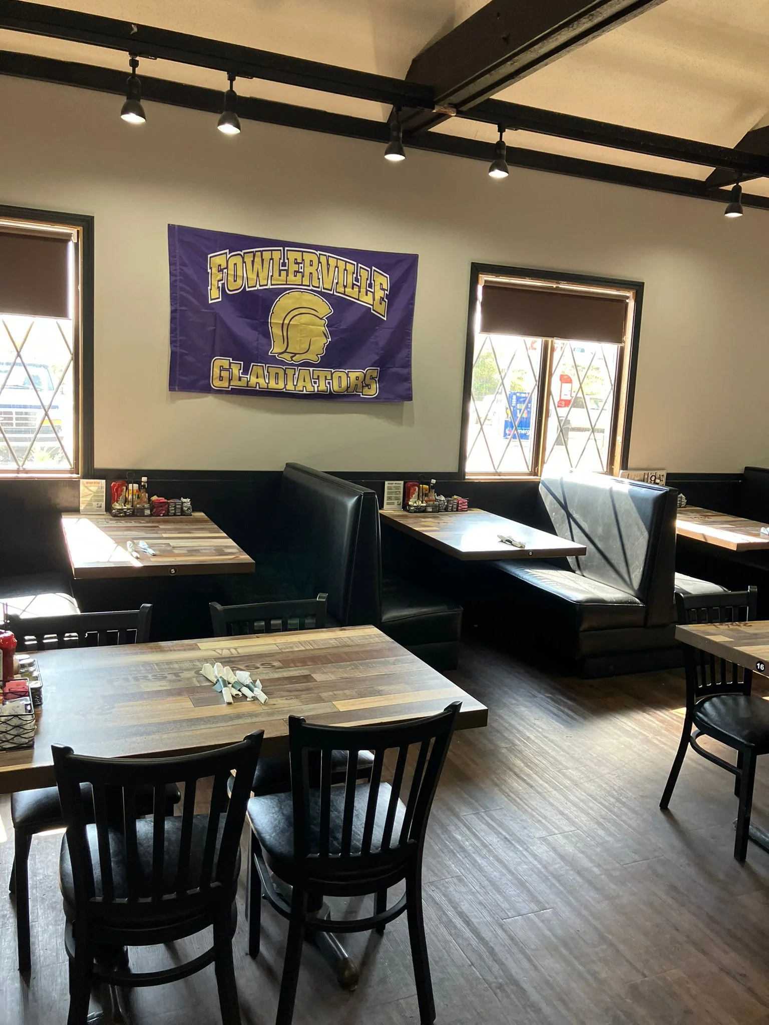 Cozy restaurant interior with Fowlerville Gladiators banner