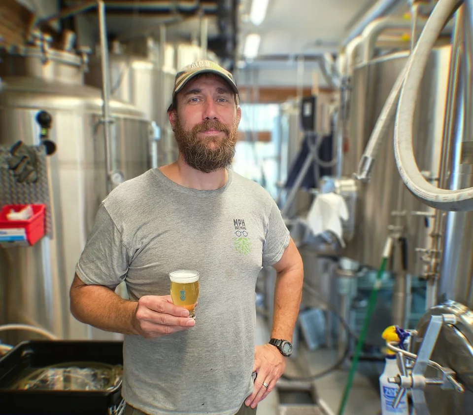 Brewmaster holding a craft beer in a brewery
