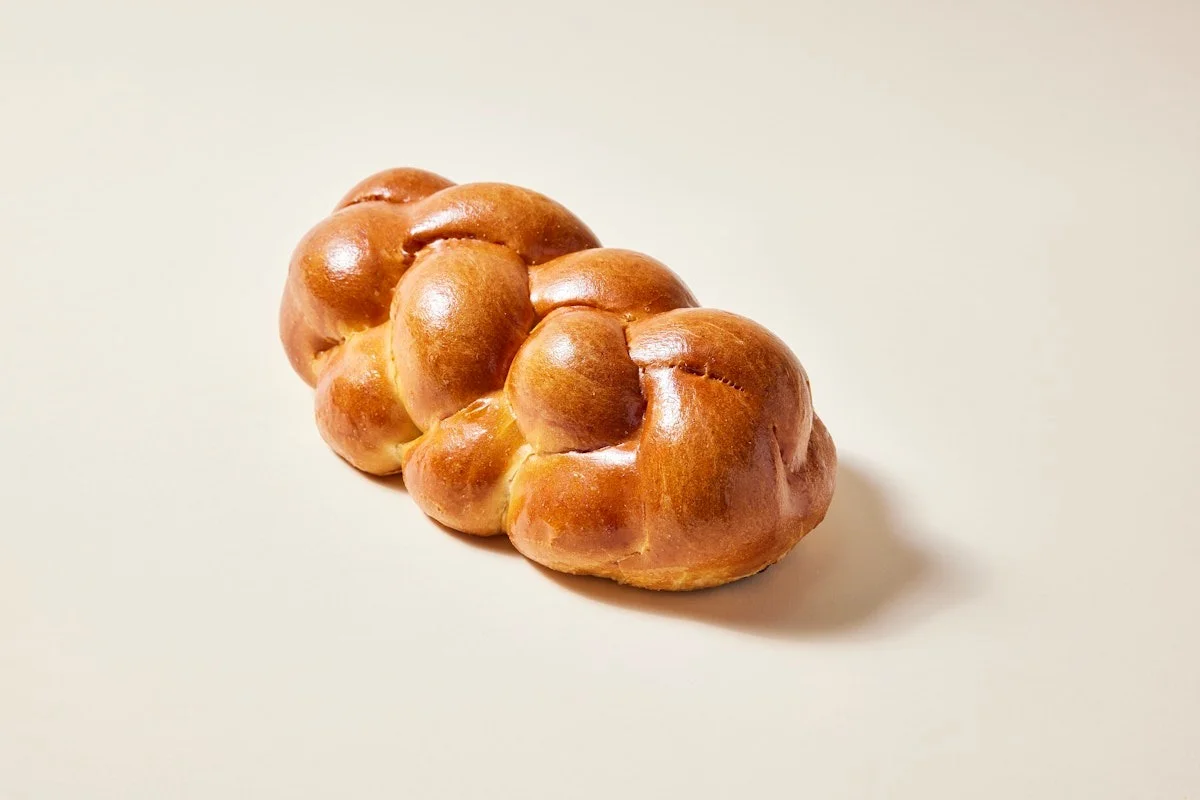 Freshly baked challah bread on a neutral background