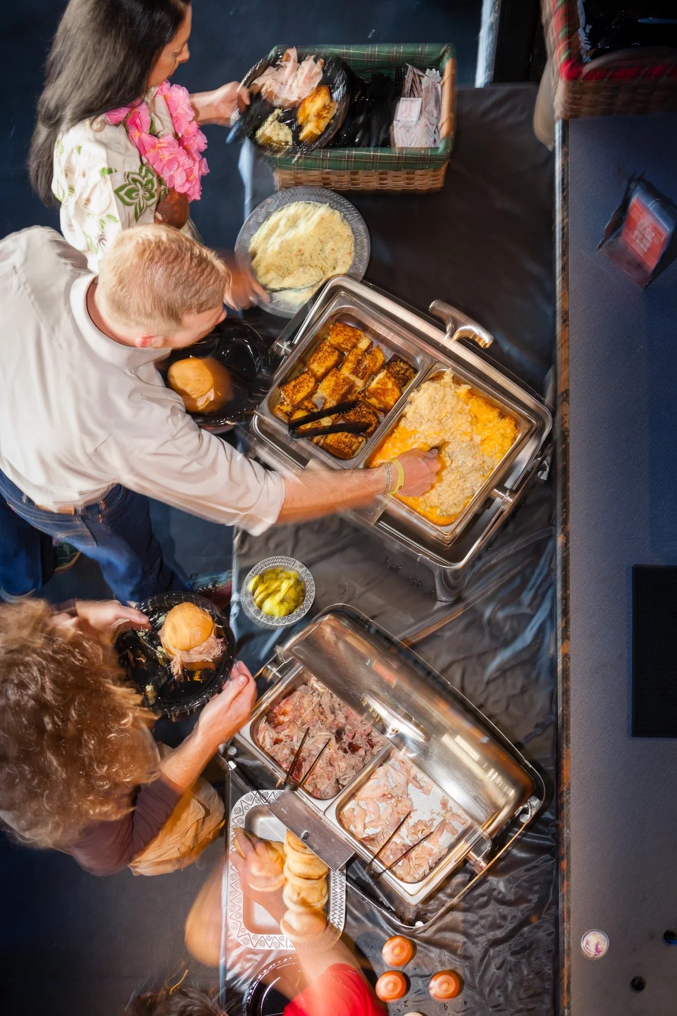 Guests serving themselves from a buffet with various dishes and sides.