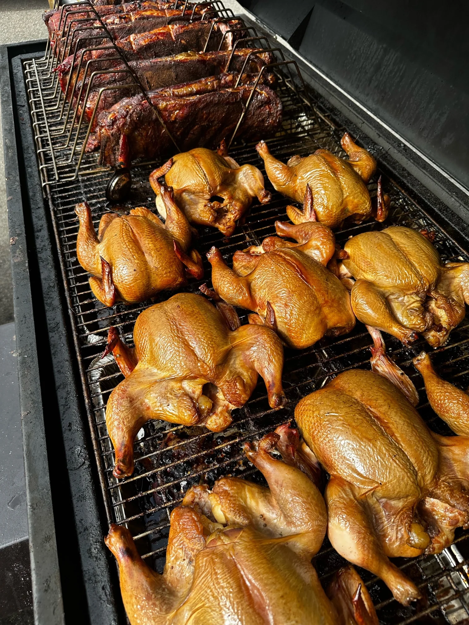Smoked barbecue chicken and ribs on a grill